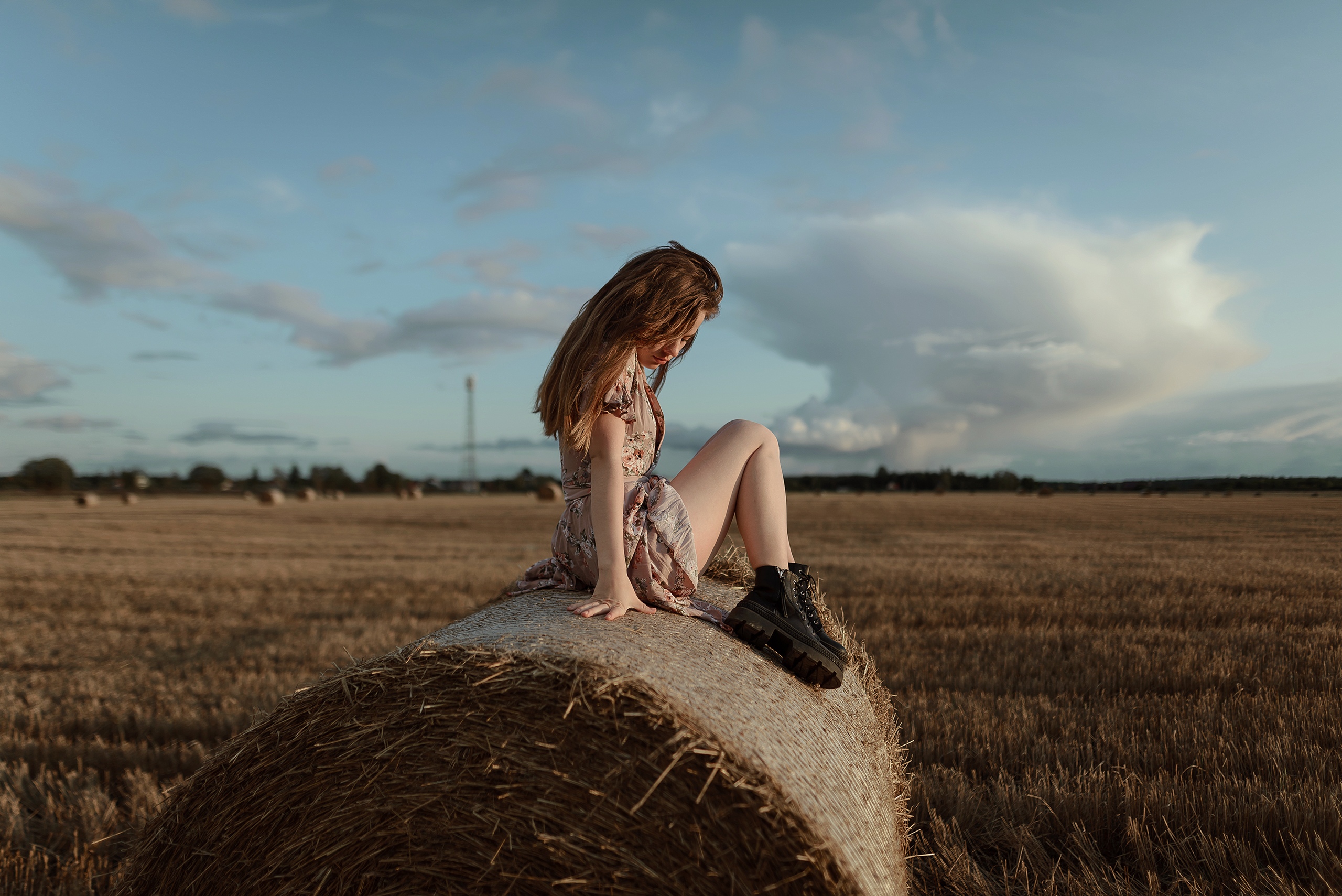Country girl sitting on a haystack
