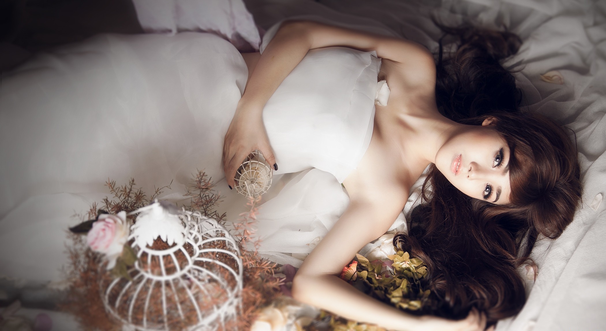 一位身着白色婚纱的亚洲女孩躺在床上