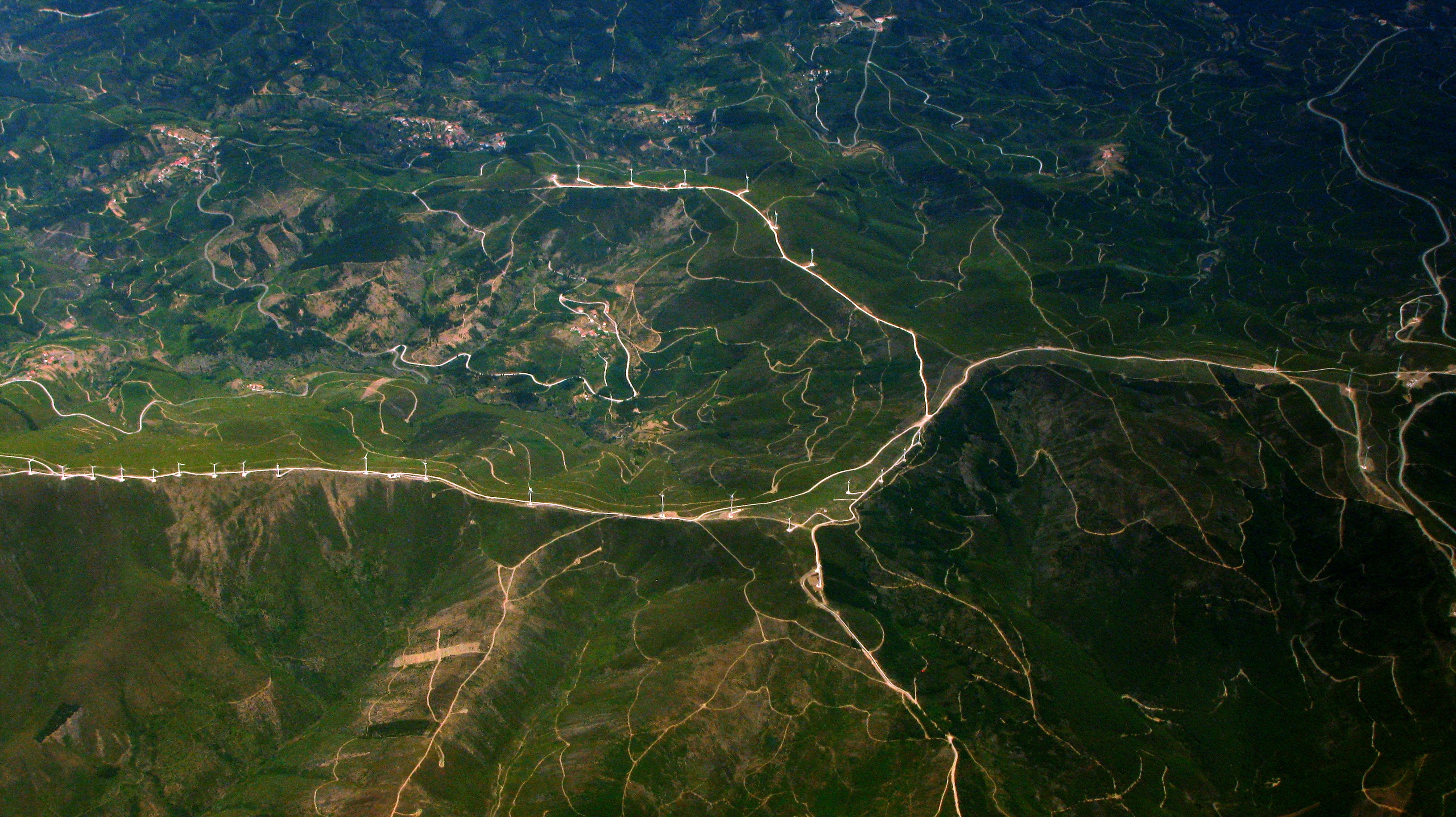 Free photo Windmills on the tops of green hills view from above