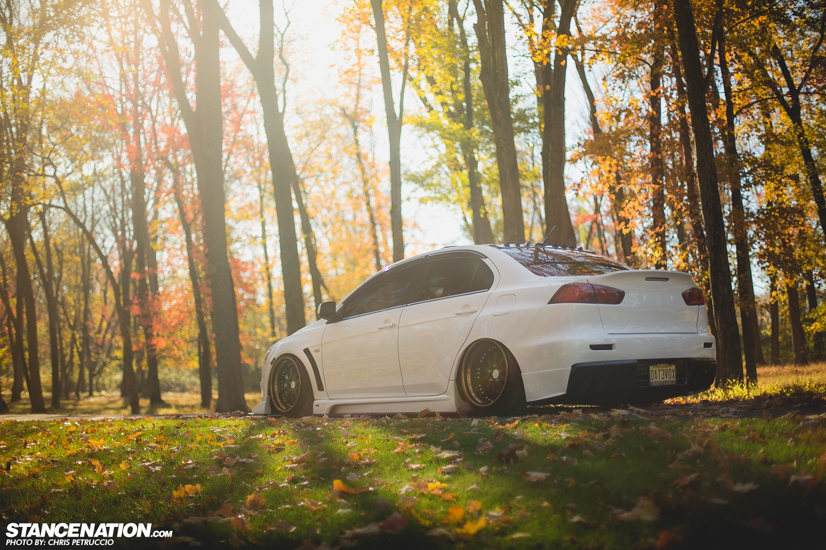 Бесплатное фото Тюнингованный Mitsubishi Lancer Evolution на фоне деревьев