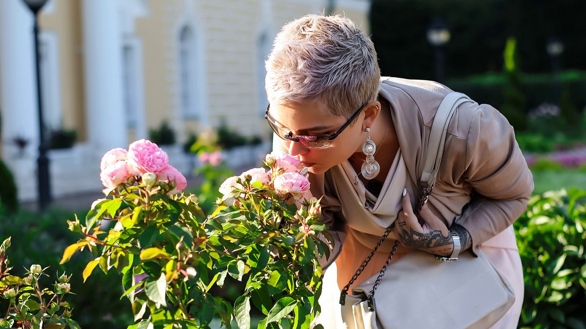Model Adele Adamova sniffs flowers on a city street