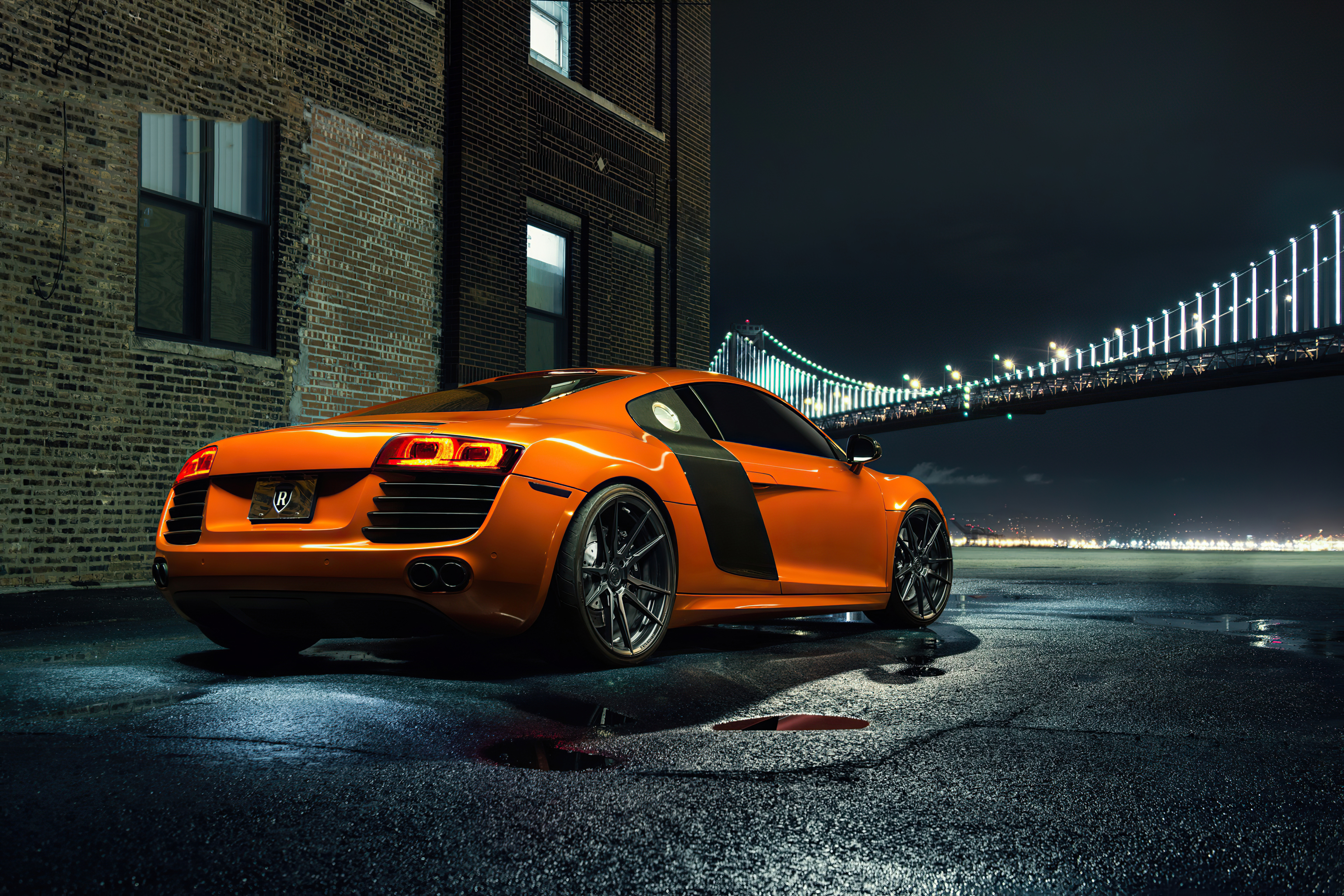 Free photo Orange Audi R8 rear view of the night bridge