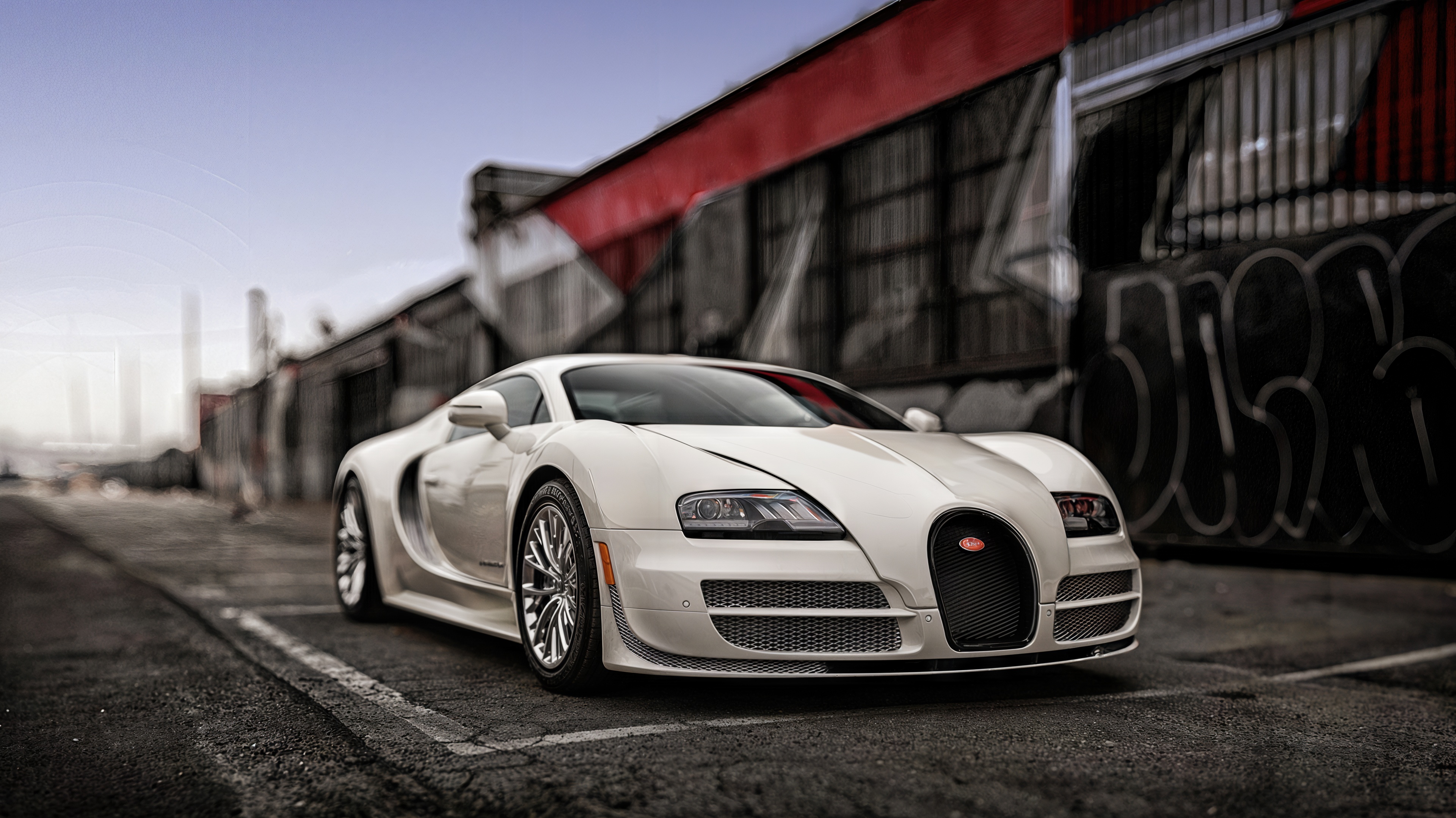 Бесплатное фото Белый Bugatti Veyron на фоне граффити - роскошь и урбанизм.
