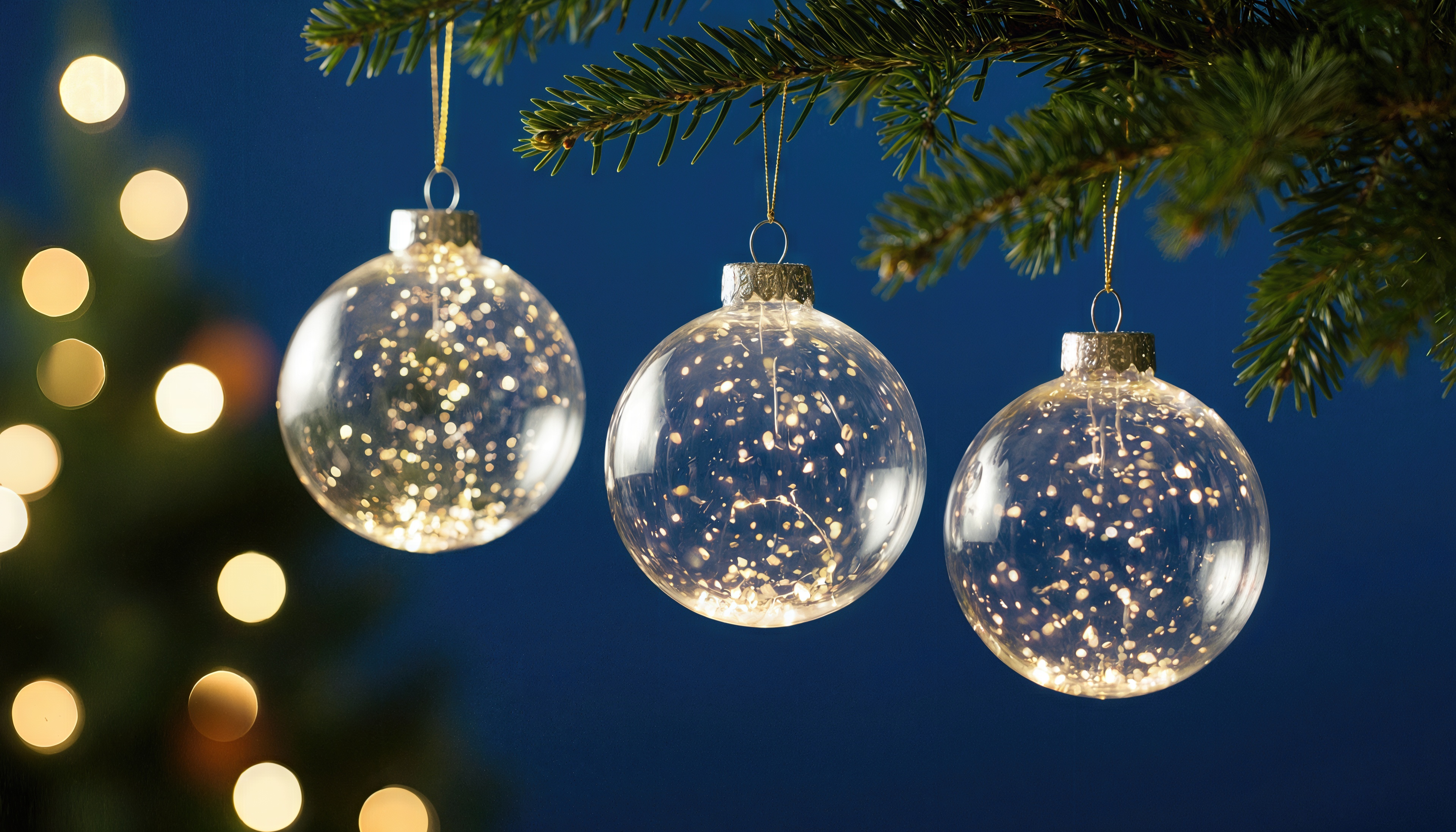 Бесплатное фото Прозрачные ёлочные шары с блёстками на еловой ветке.