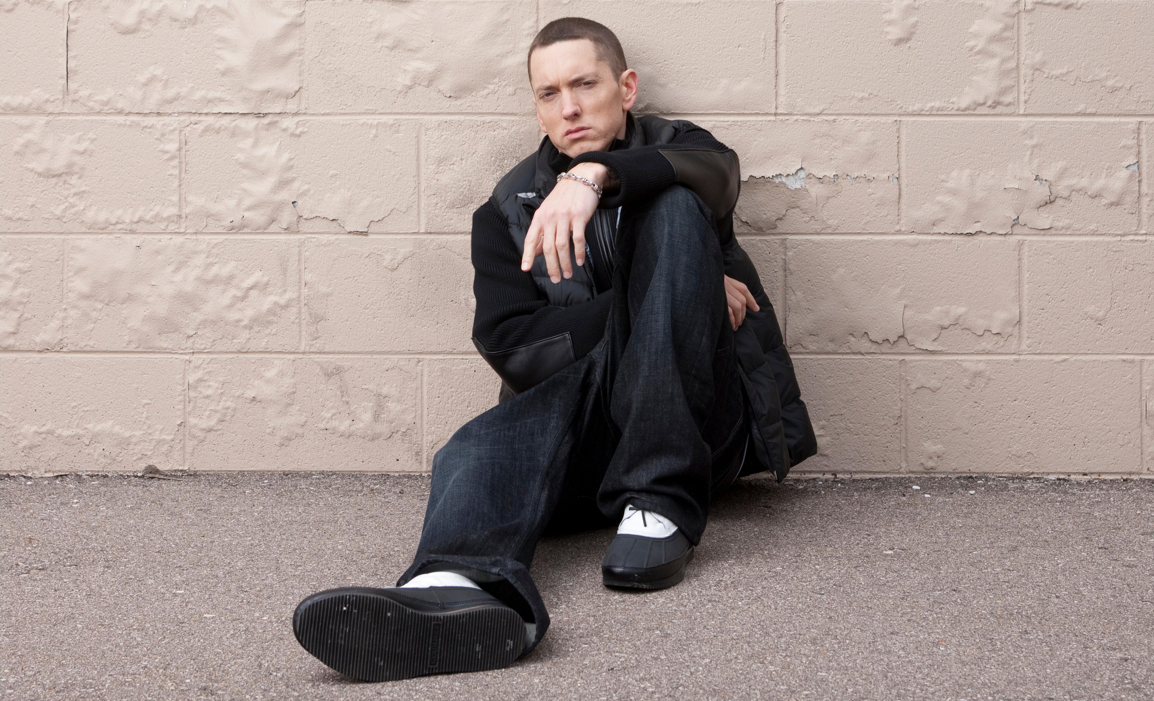 Rapper Eminem sits against the wall