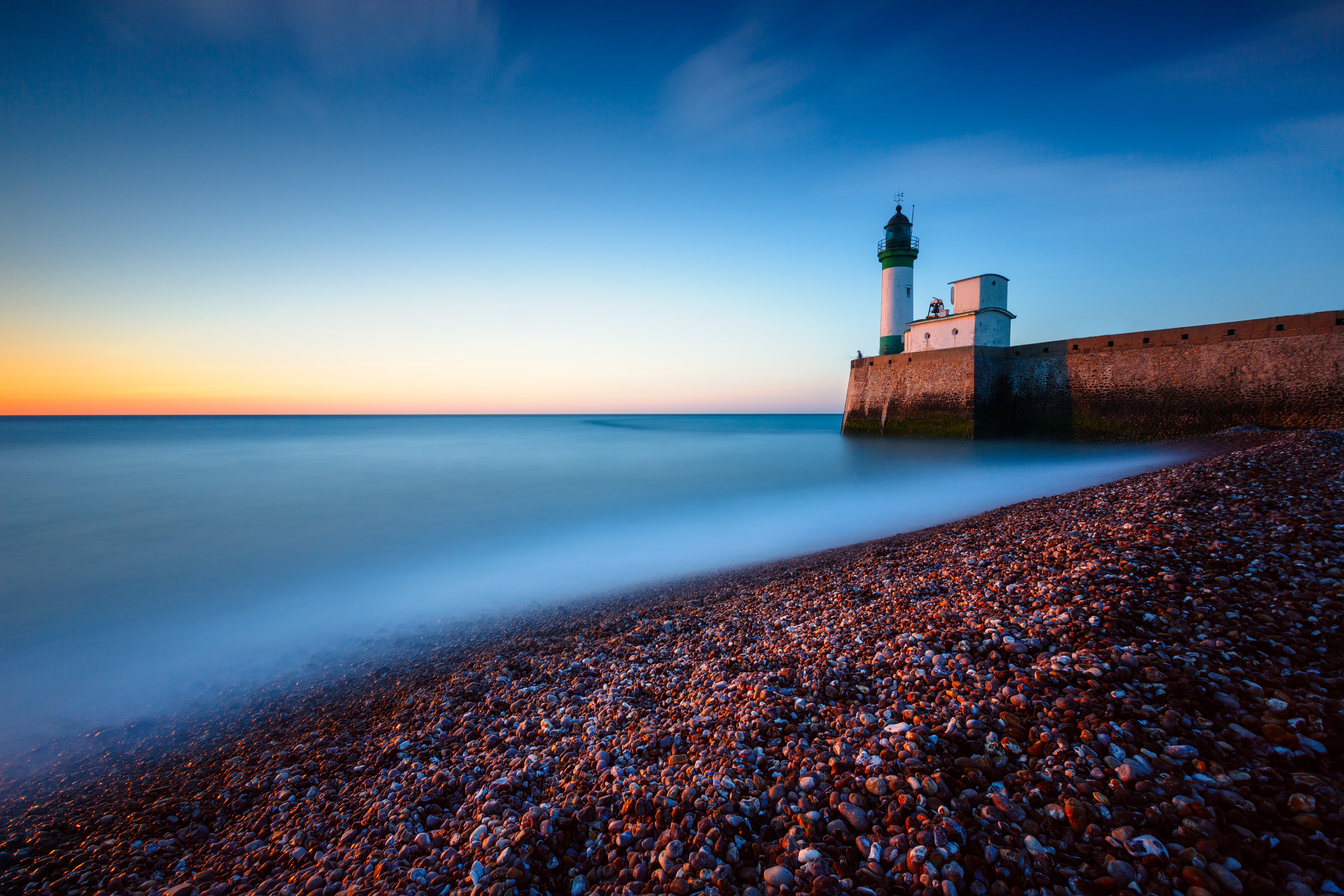 Free photo Lighthouse on the pier during sunset