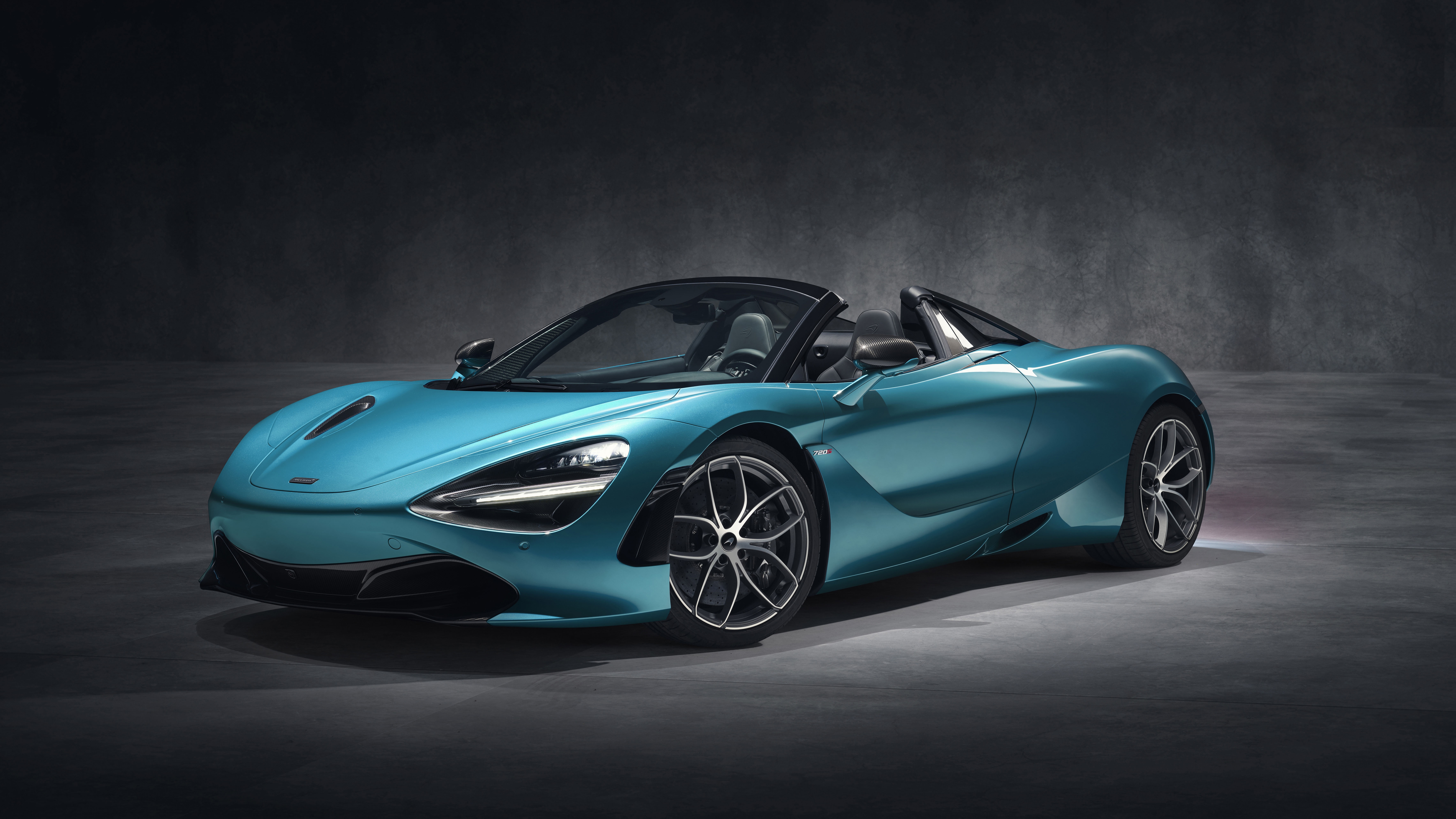 Бесплатное фото Mclaren 720S Spider голубого цвета в темном помещении