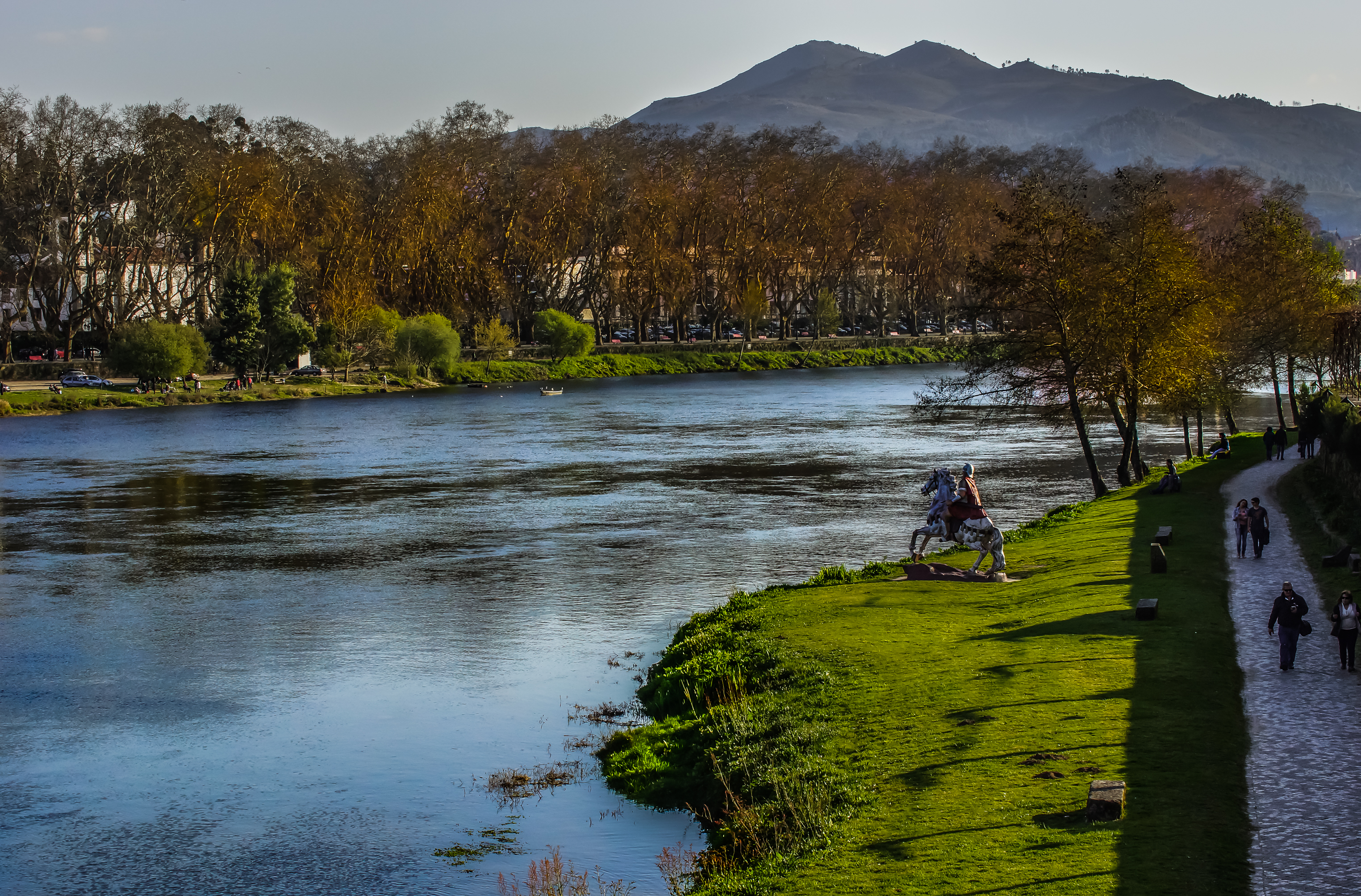 Free photo Monument of a knight in armor on a horse on the river bank