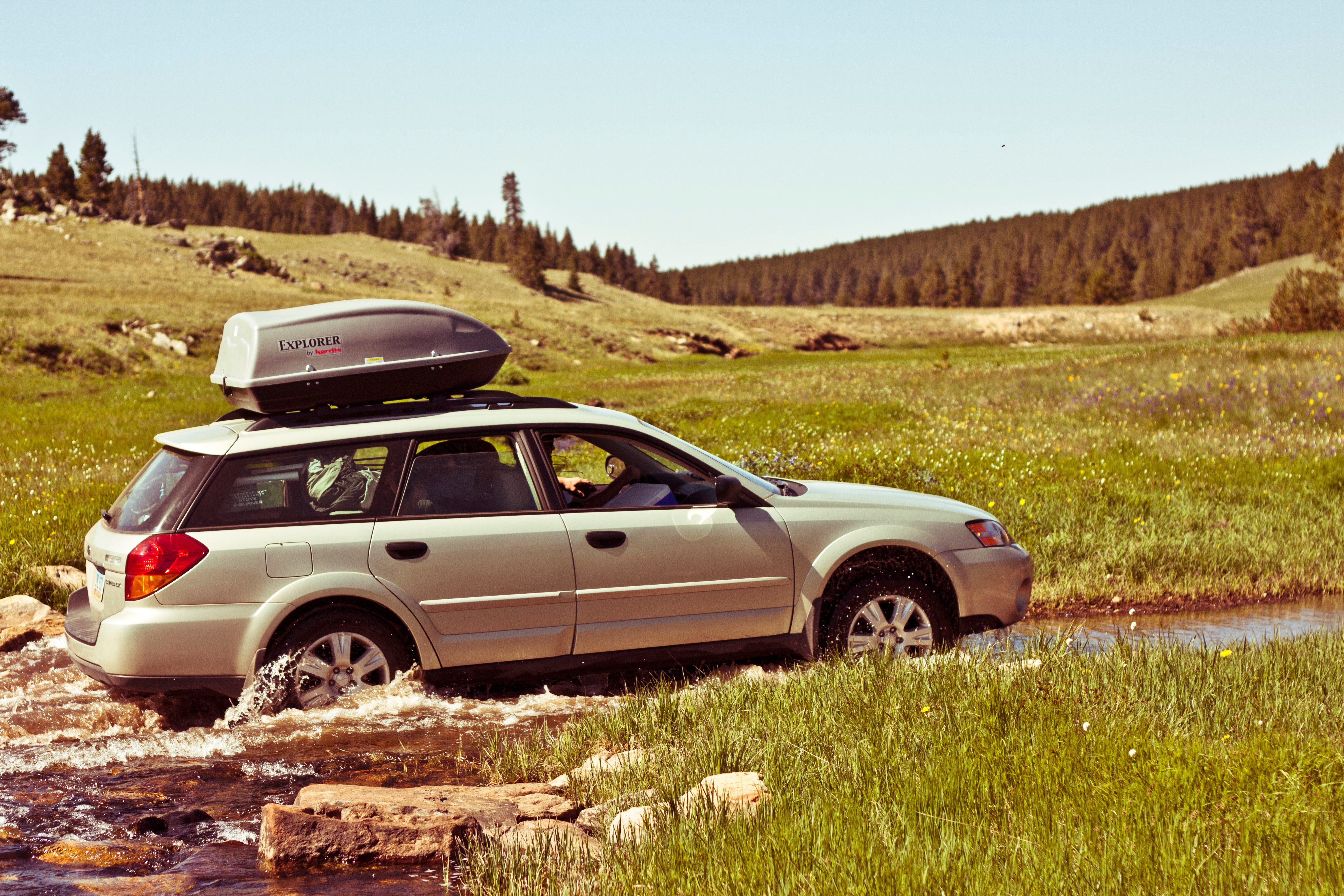 Free photo The Subaru is driving down a dirt road on dirt.