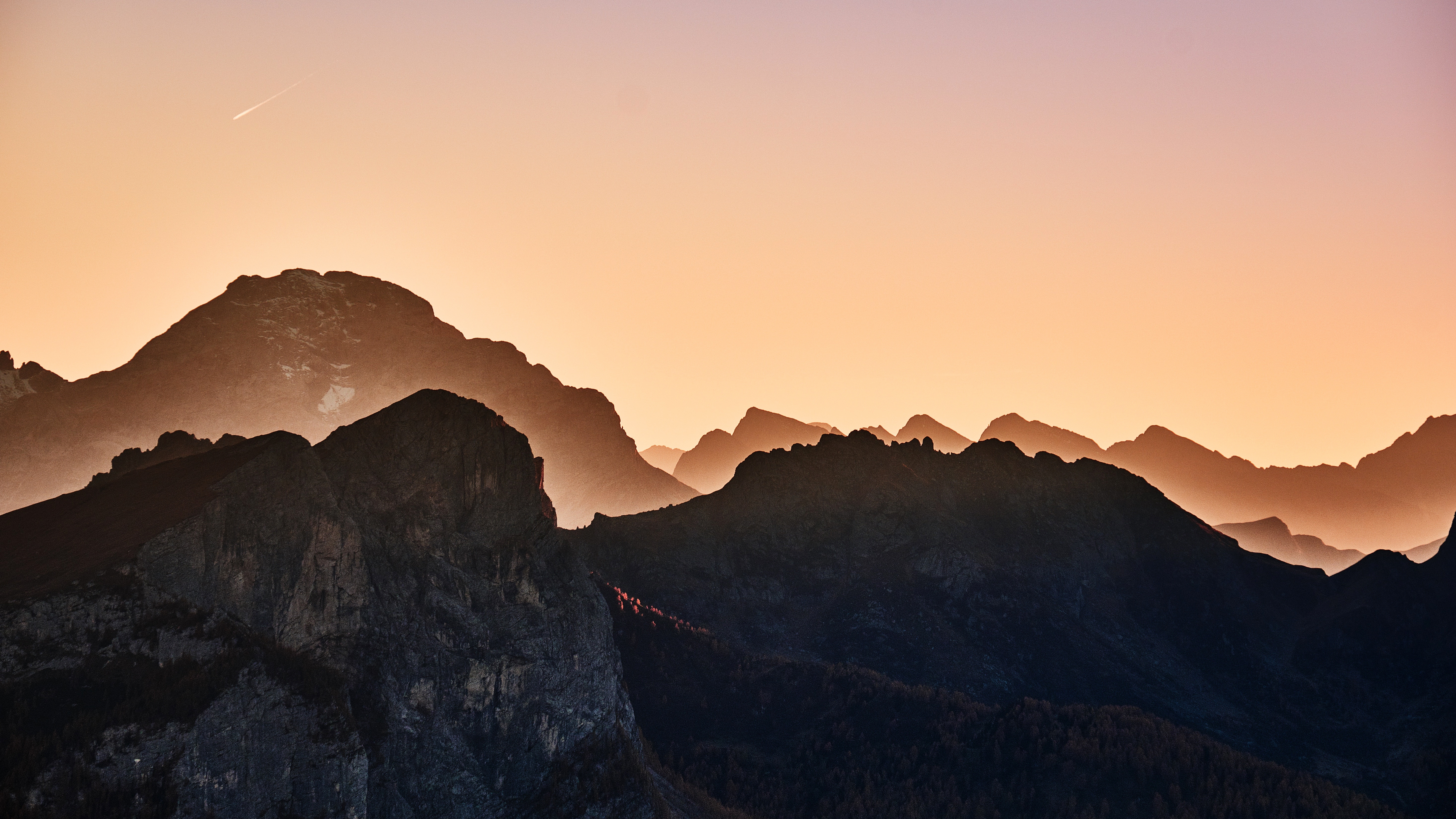 Free photo Mountain hills against a colorful sky with a shooting star