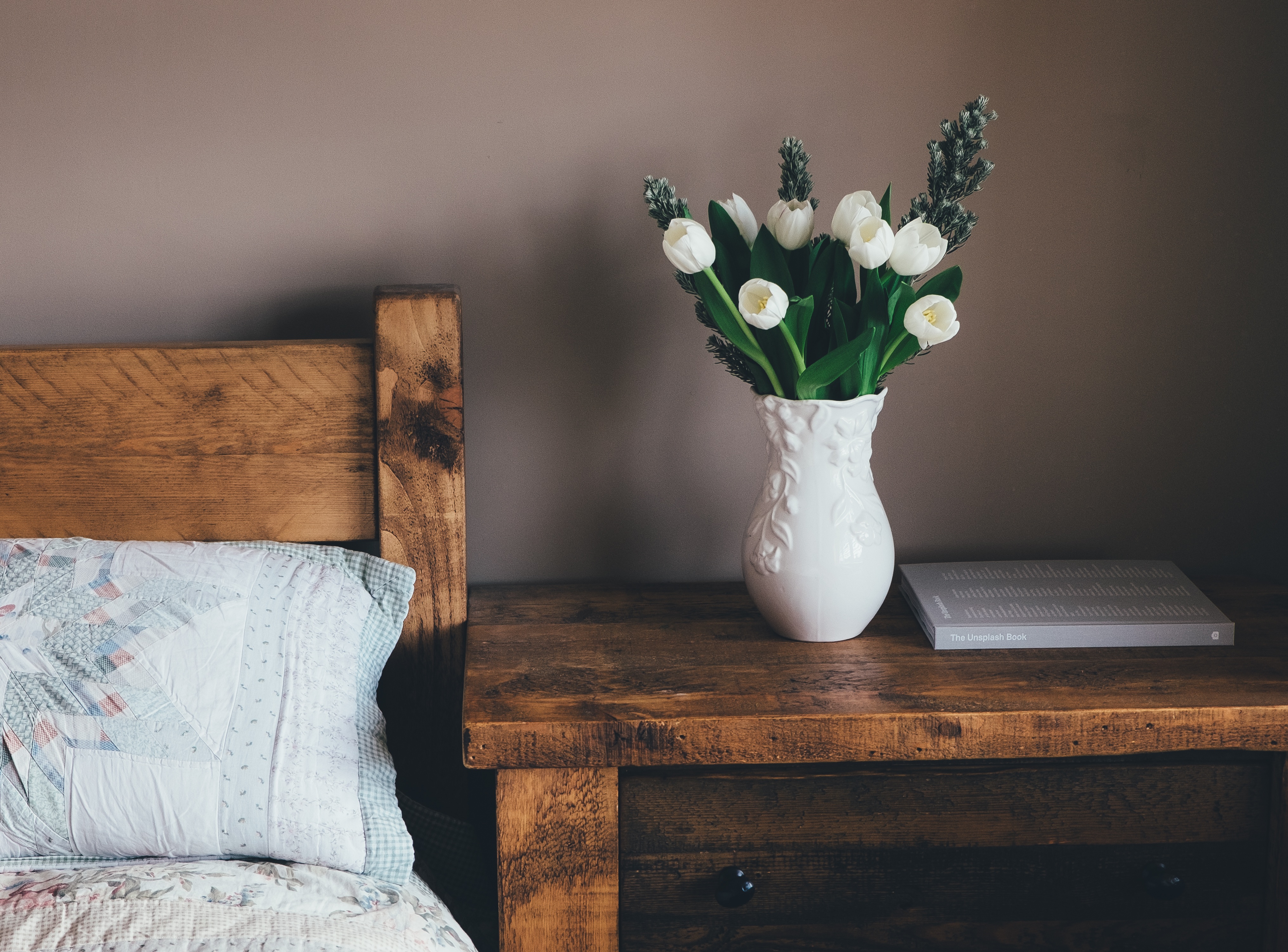 Free photo Bouquet with white tulips in a vase by the bed