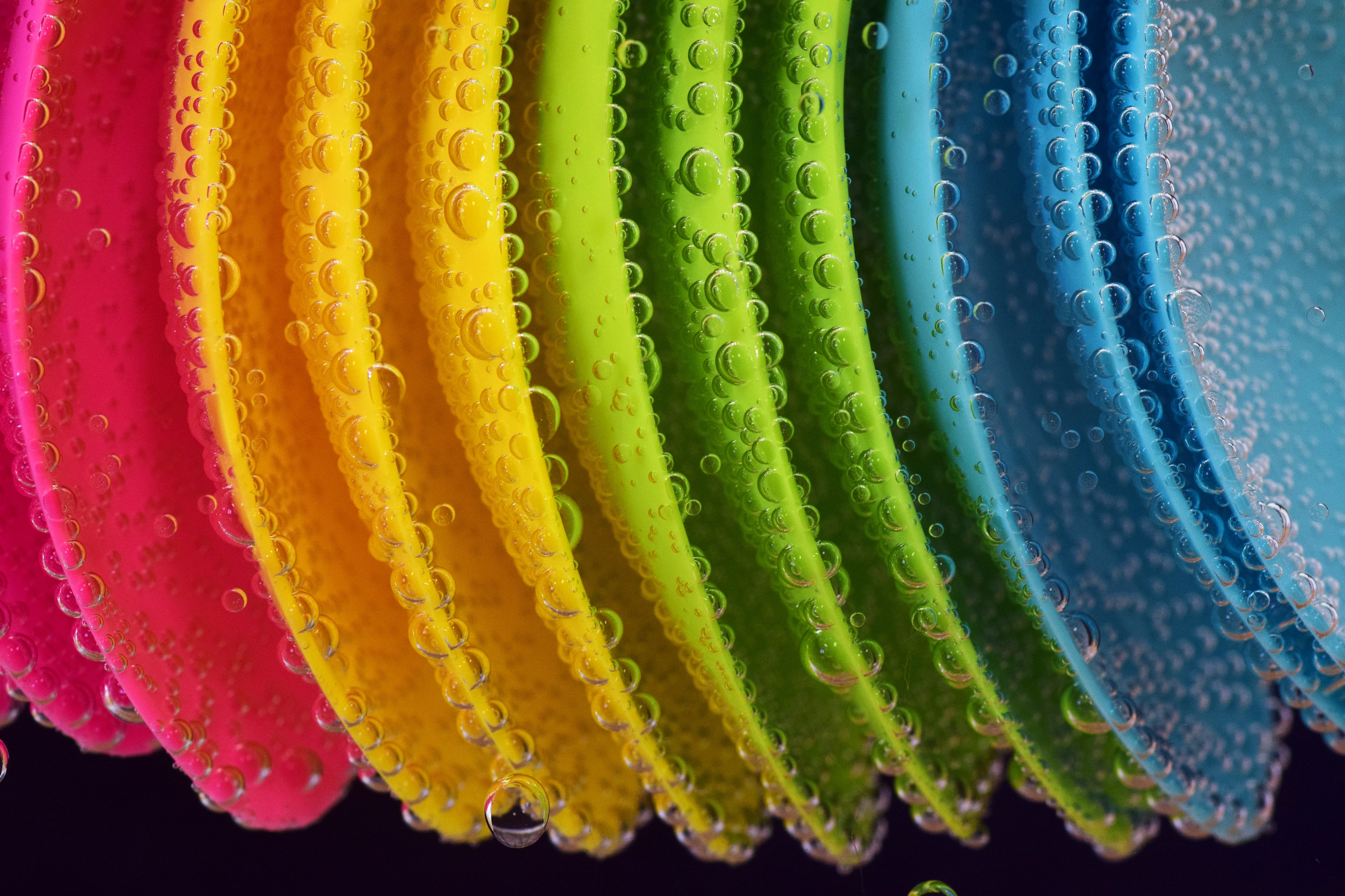 免费照片水中的彩色塑料勺