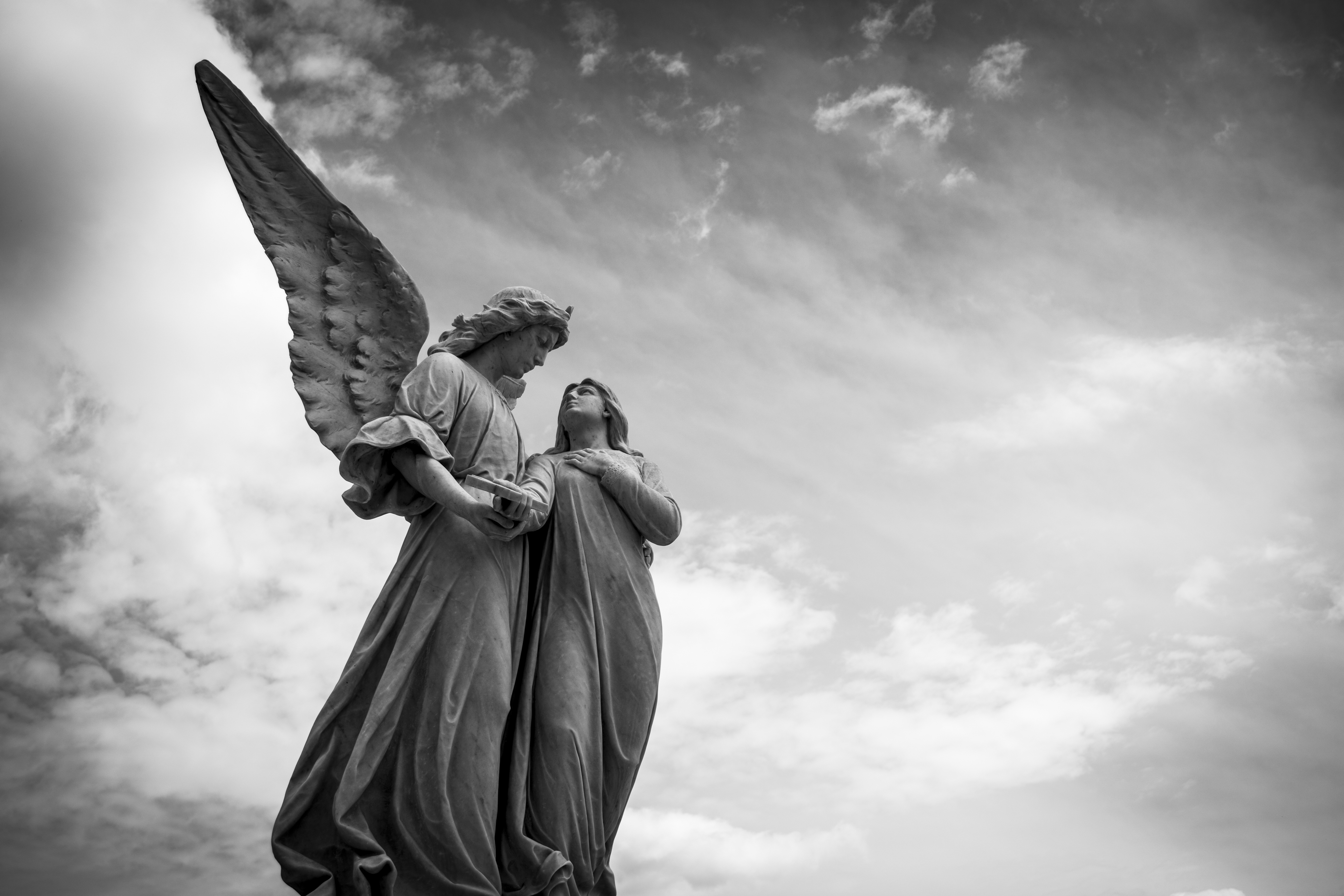 Бесплатное фото Статую ангела с крыльями держащего человека за руку
