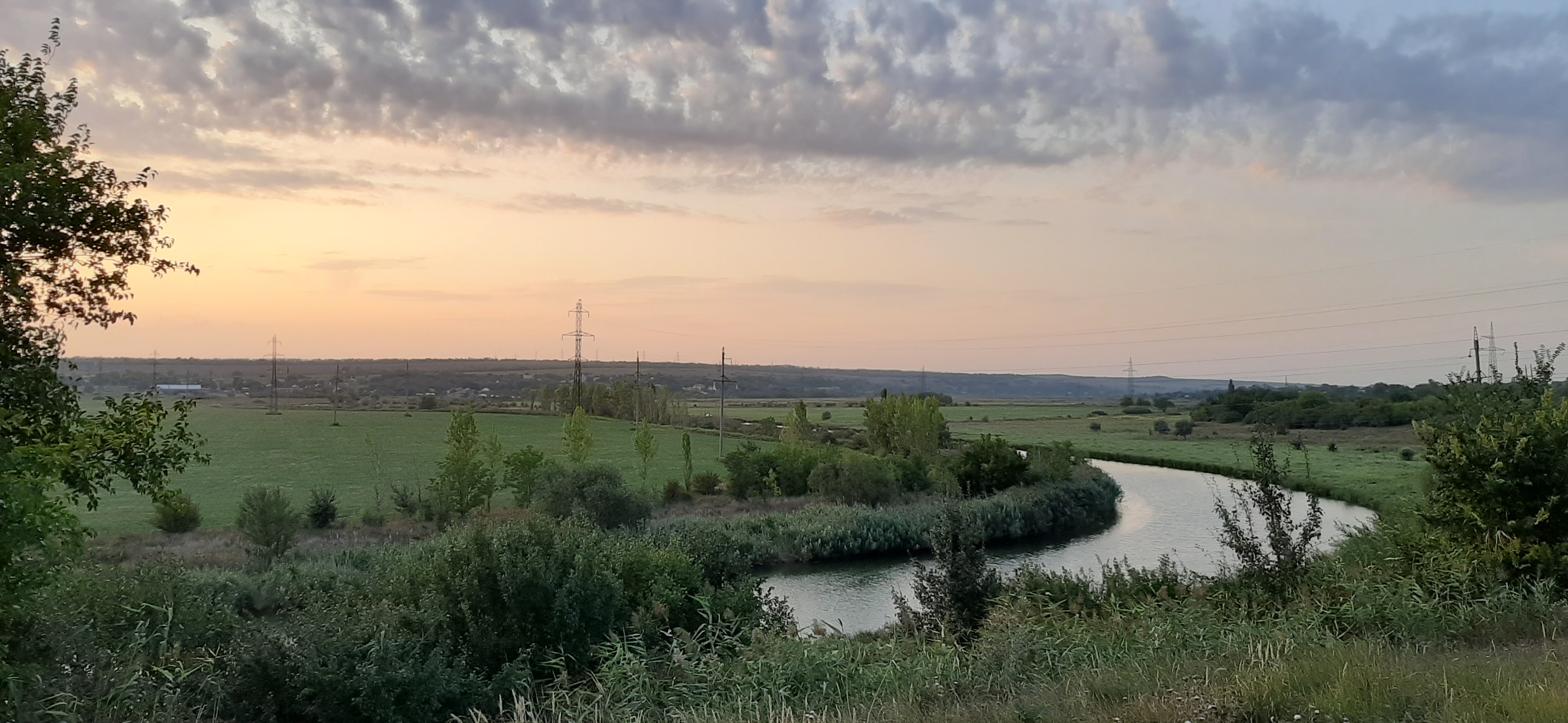 Free photo Sunset on the river and a green field