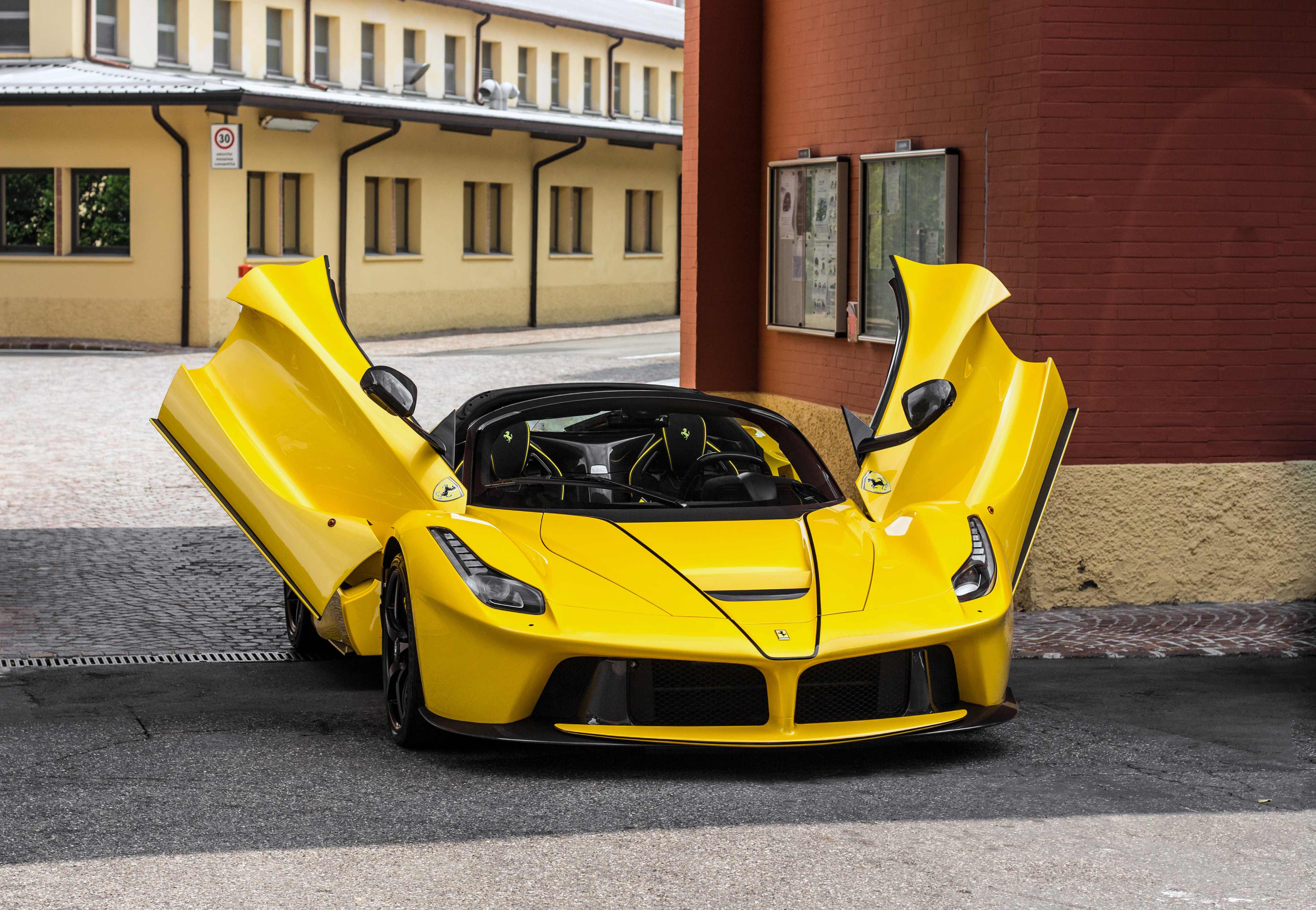 A yellow Laferrari with the doors open.