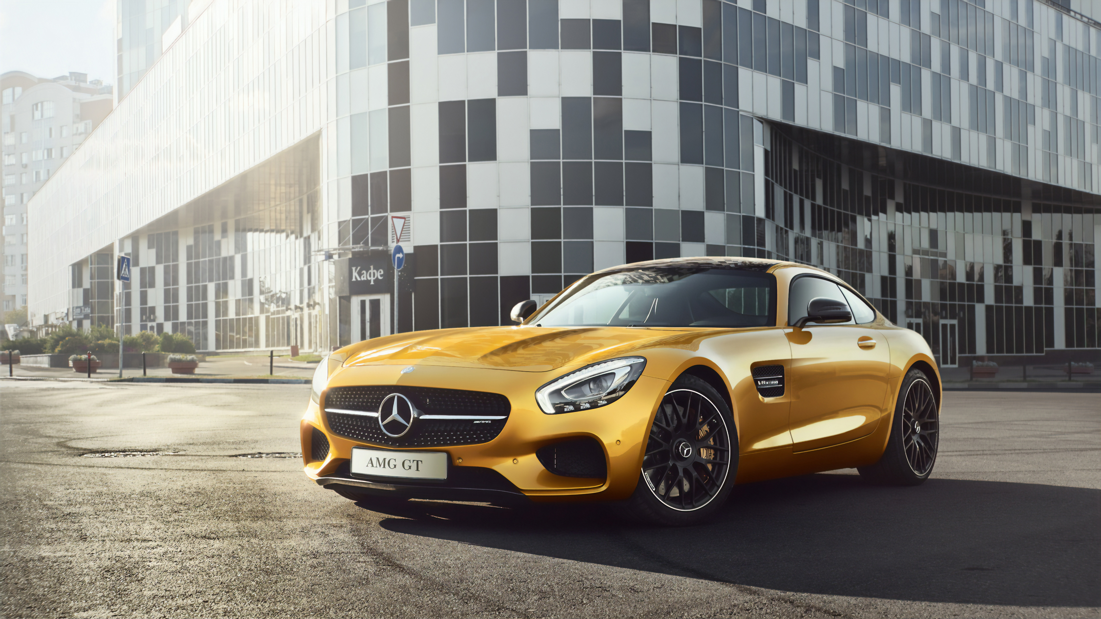 Free photo A yellow Mercedes AMG GTR stands in front of a house on a sunny street