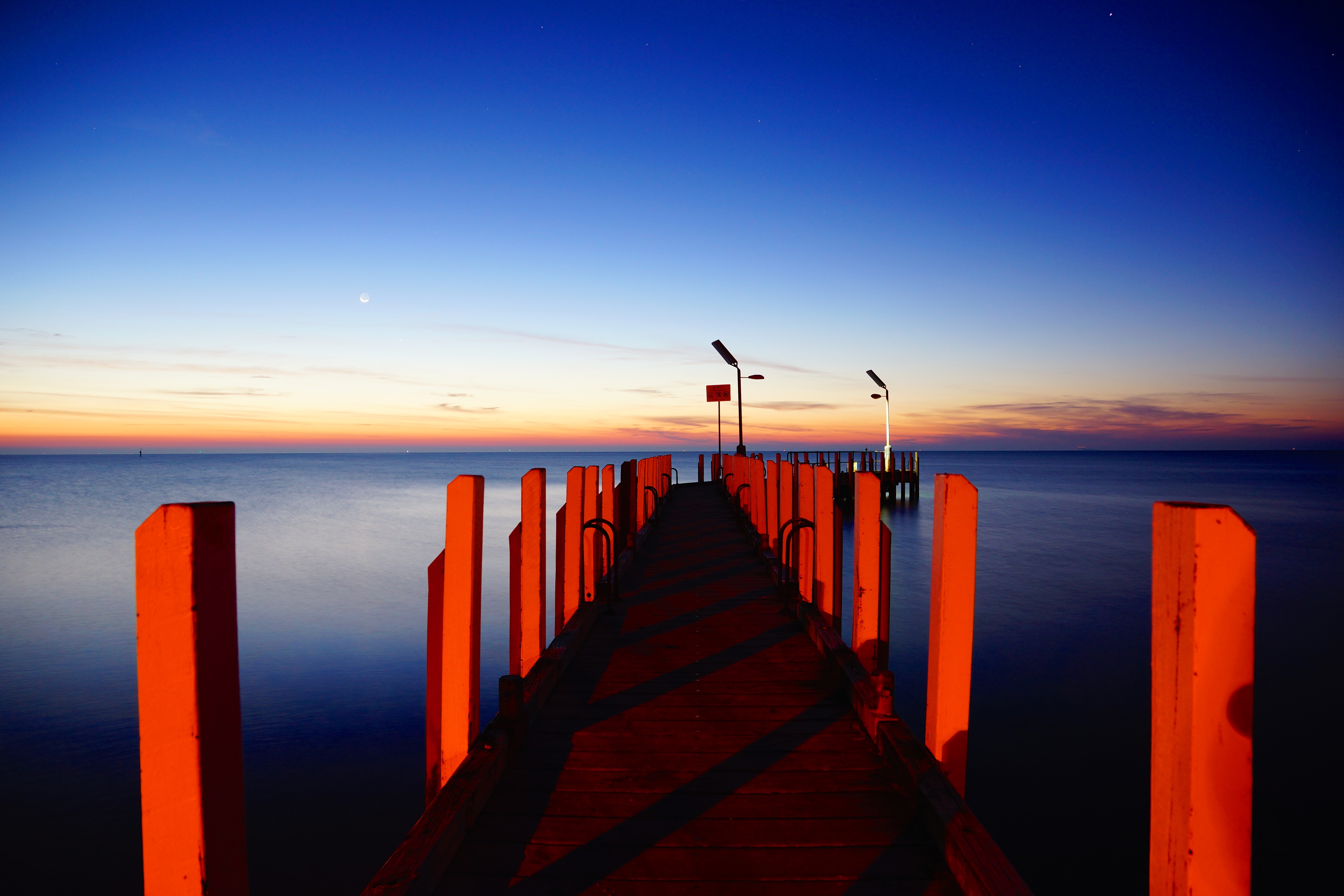 Free photo A bridge on the seashore at dawn