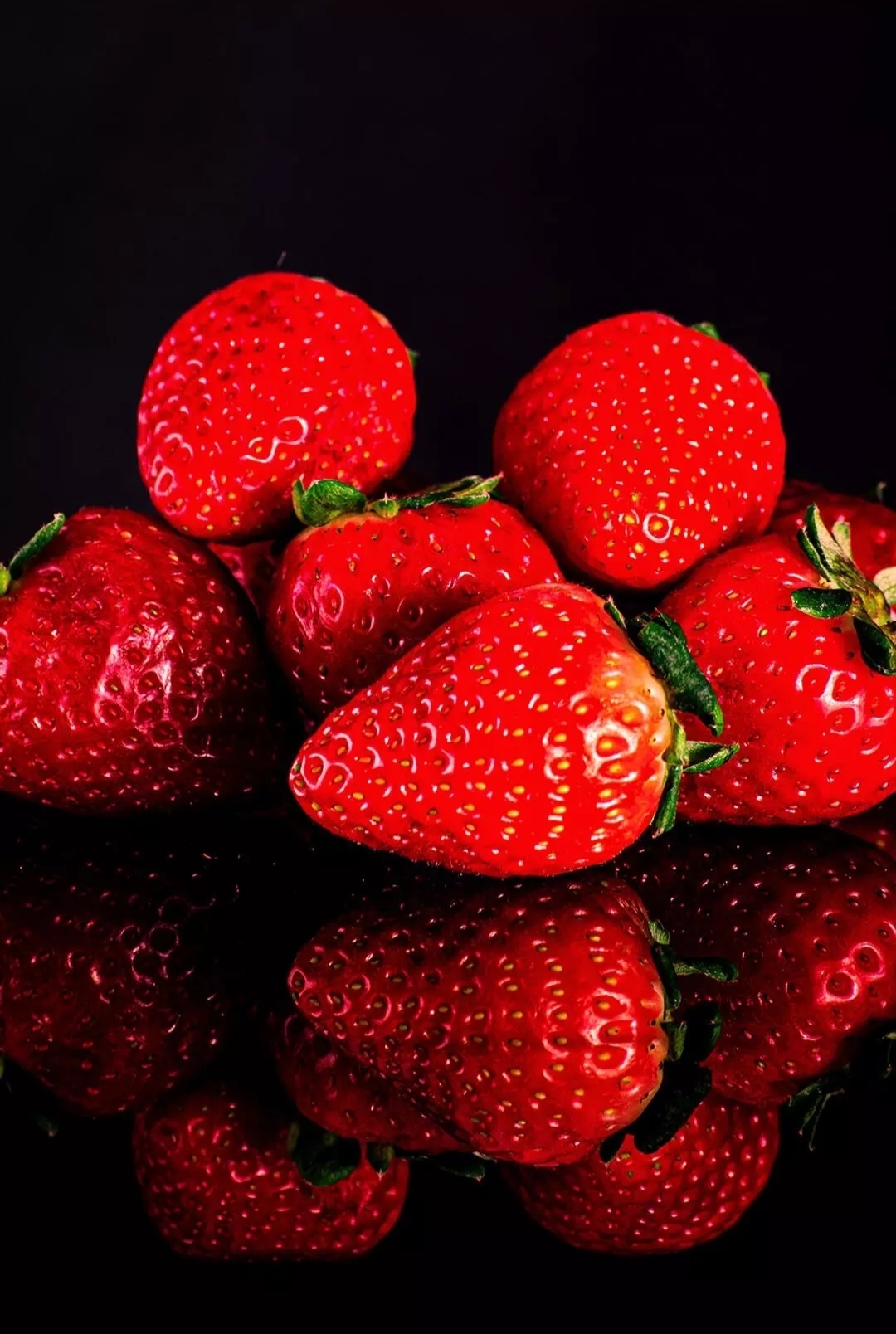 Бесплатное фото Клубника эффектно разложенная на зеркальной поверхности.