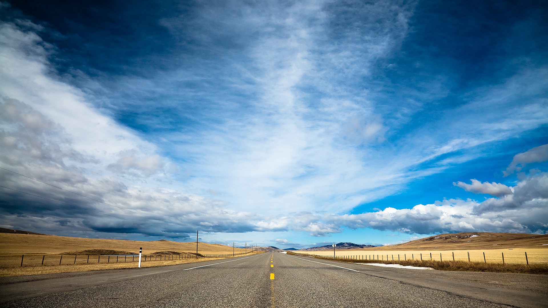 A road going off into the distance under a cloudy sky.