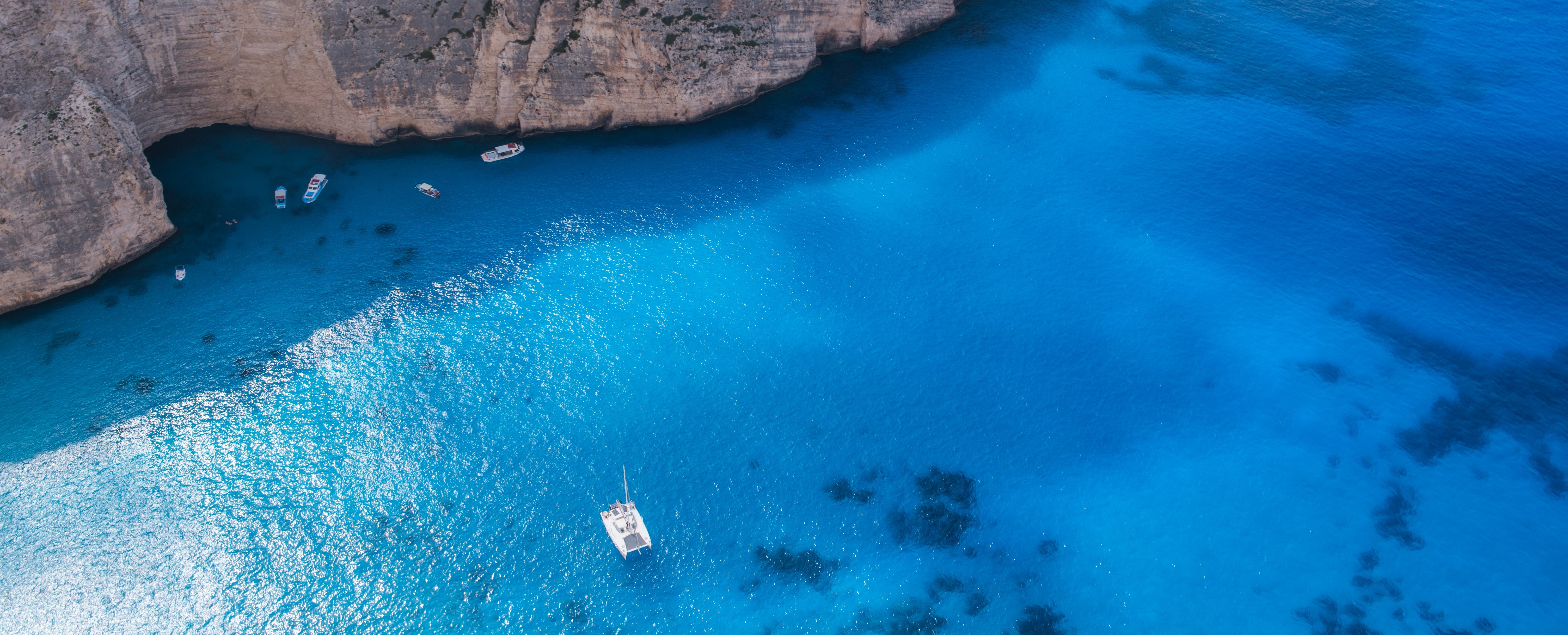 Free photo A picture of a lonely sailboat in a blue lagoon.