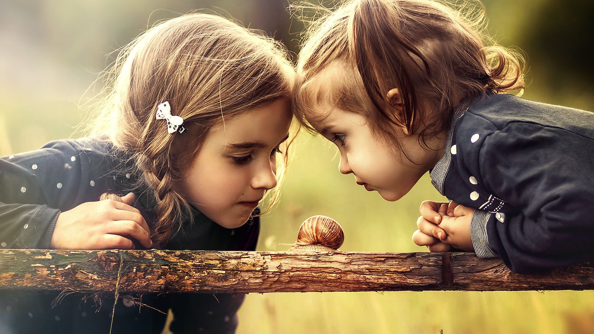 两个小姑娘在玩蜗牛