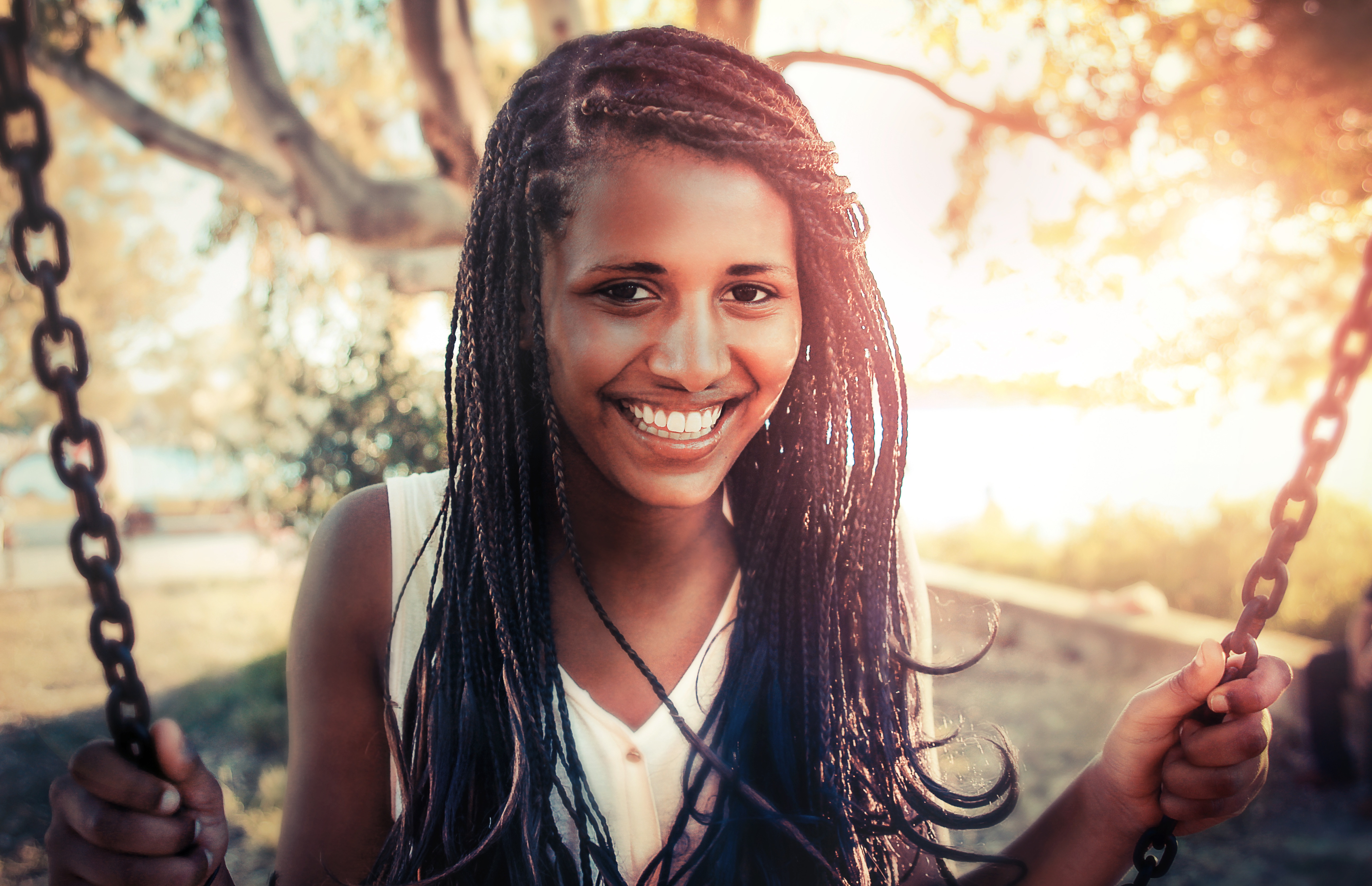 Free photo Black girl with pigtails swinging on a swing set