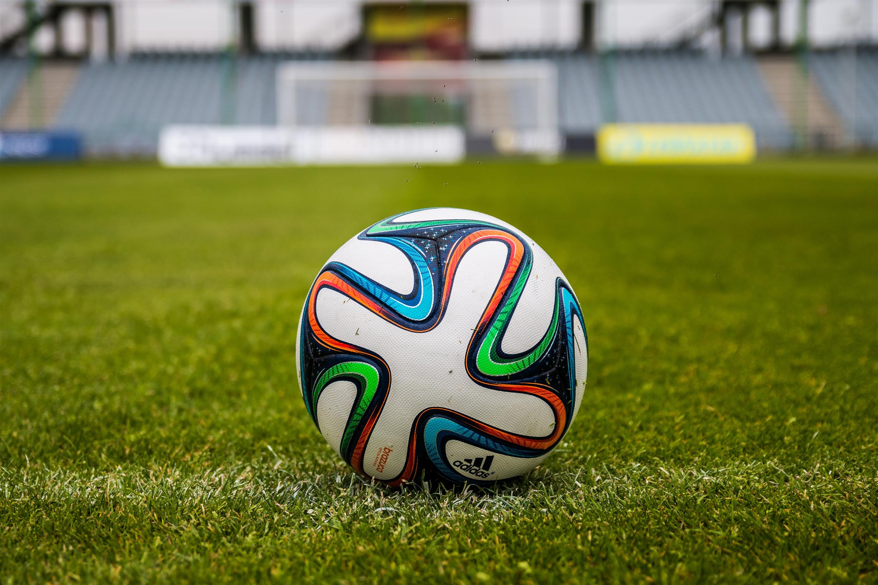 Бесплатное фото Футбольный мяч на зеленом газоне