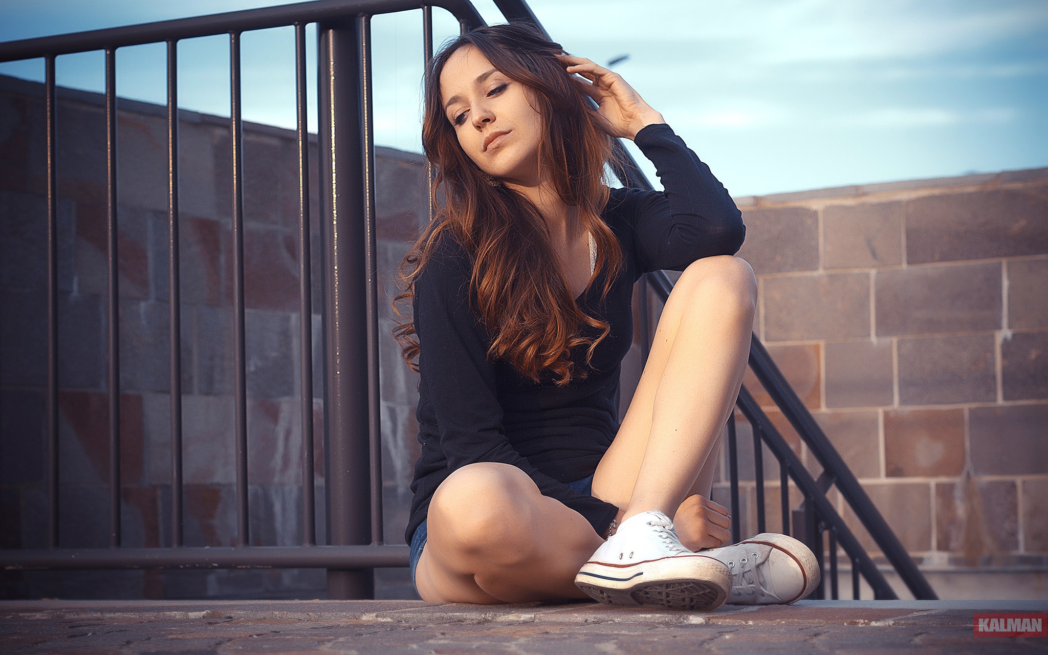 Free photo A beautiful brunette sits at the railing