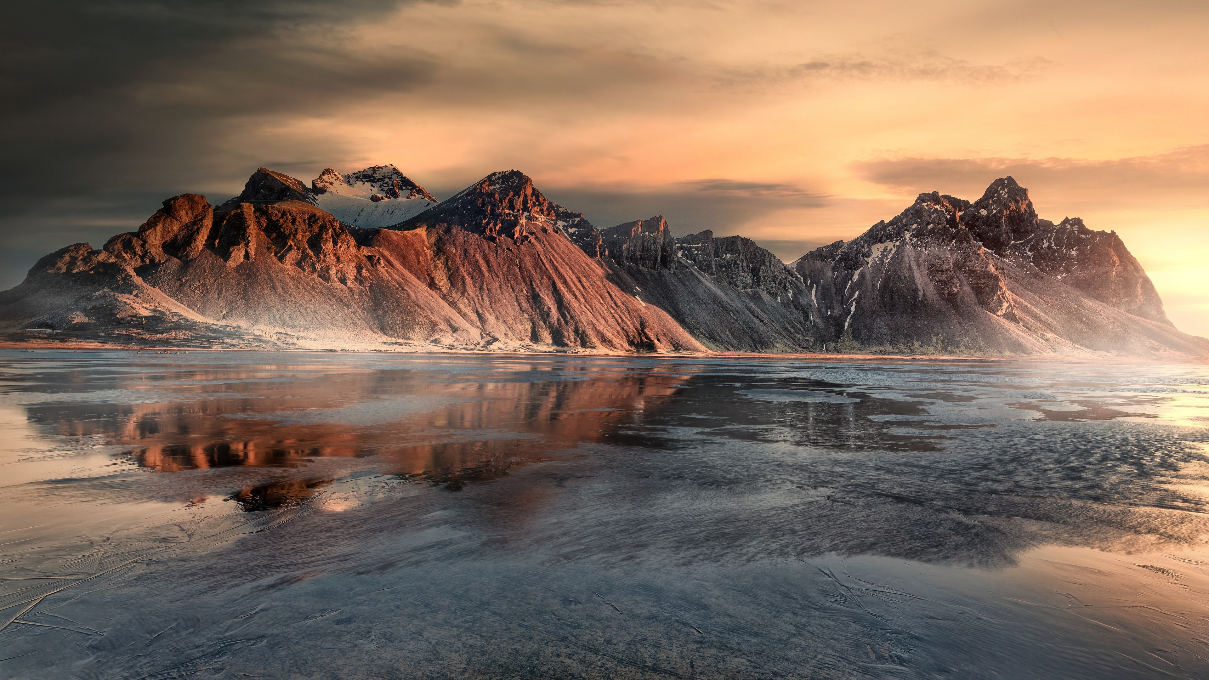 Free photo A frozen river next to some small mountains