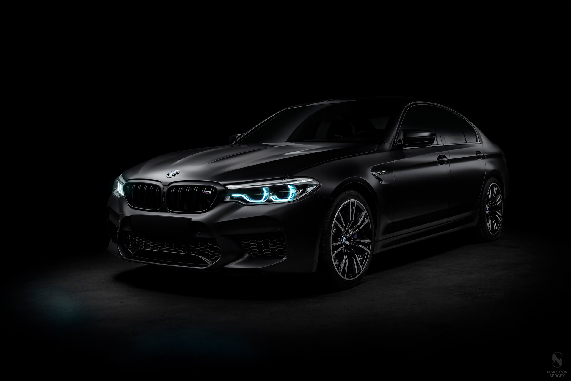 Бесплатное фото Черная матовая BMW M5 F90 на черном фоне