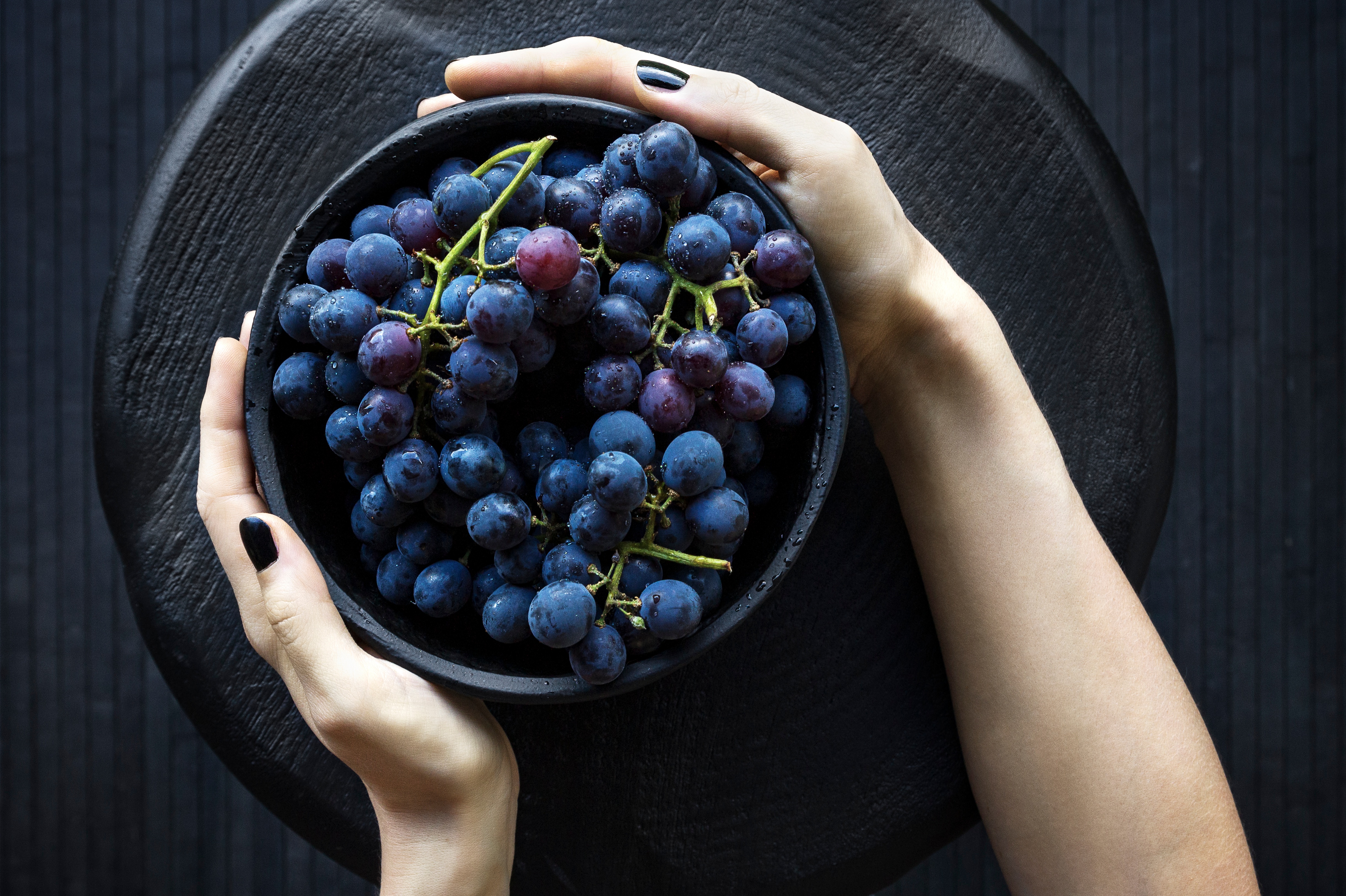 Free photo A large plate of blue grapes.