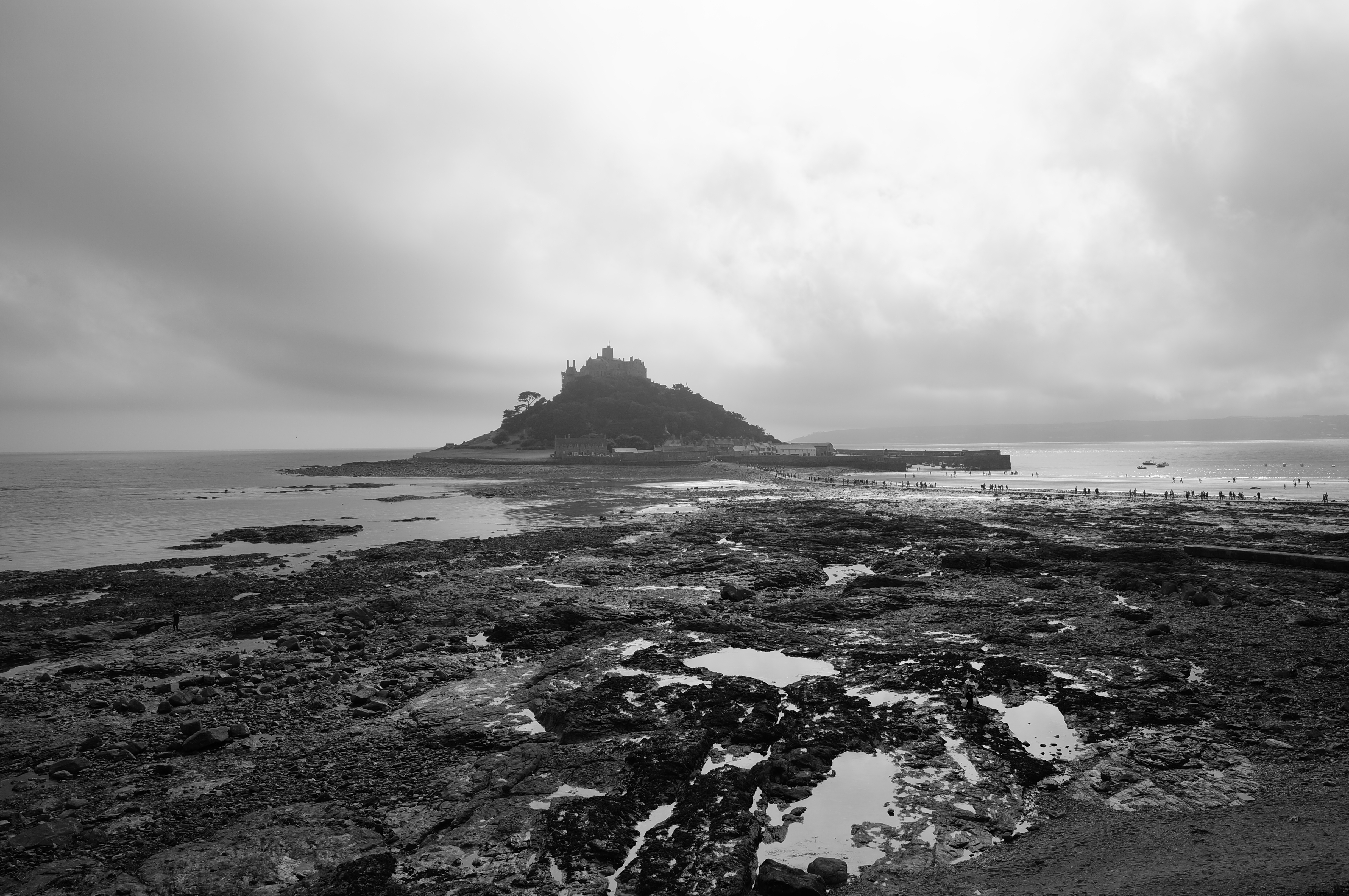 Черно белая фотография где стоит одинокий замок на вершине скал