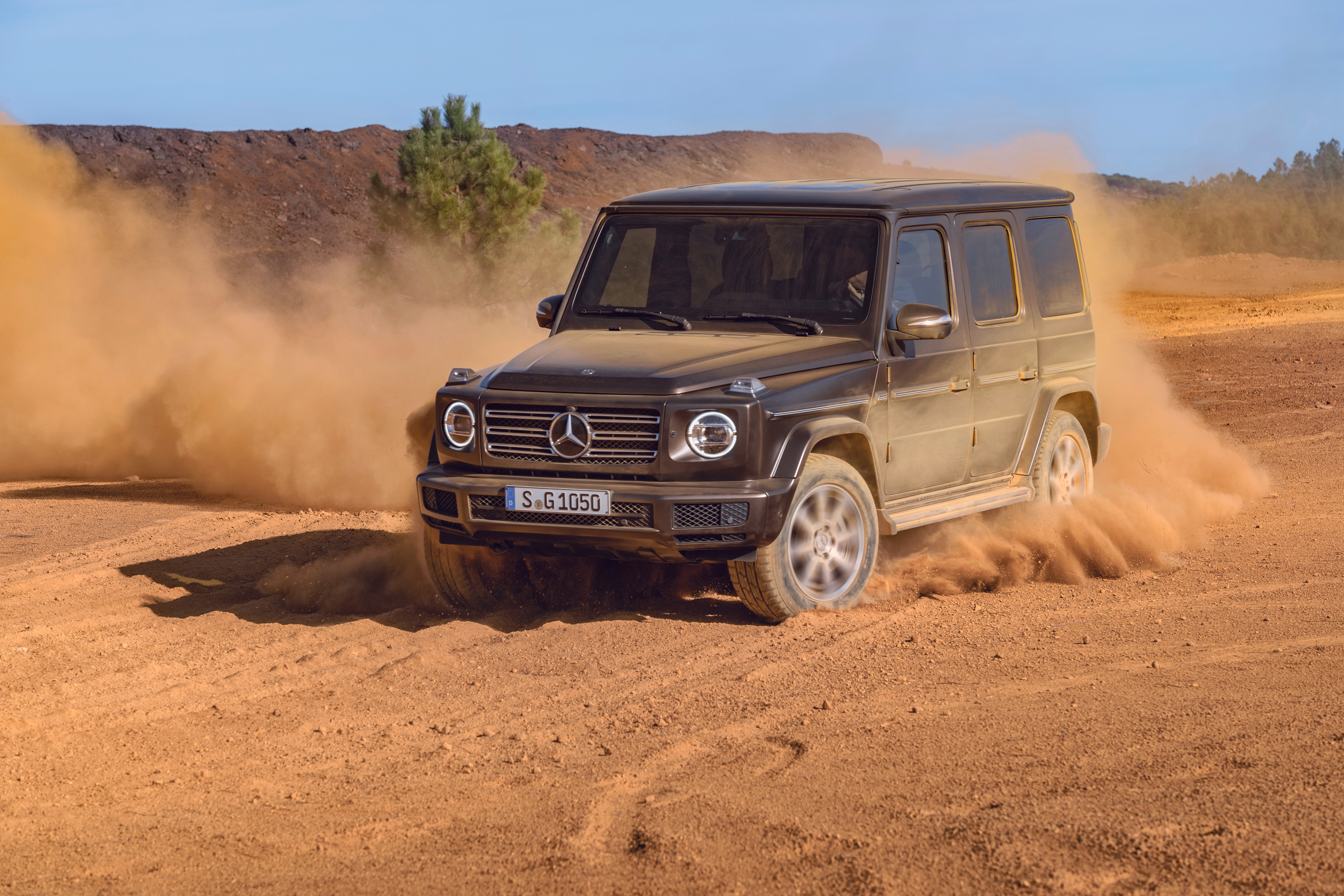 Free photo The black 2019 Mercedes G Class drives through the dust