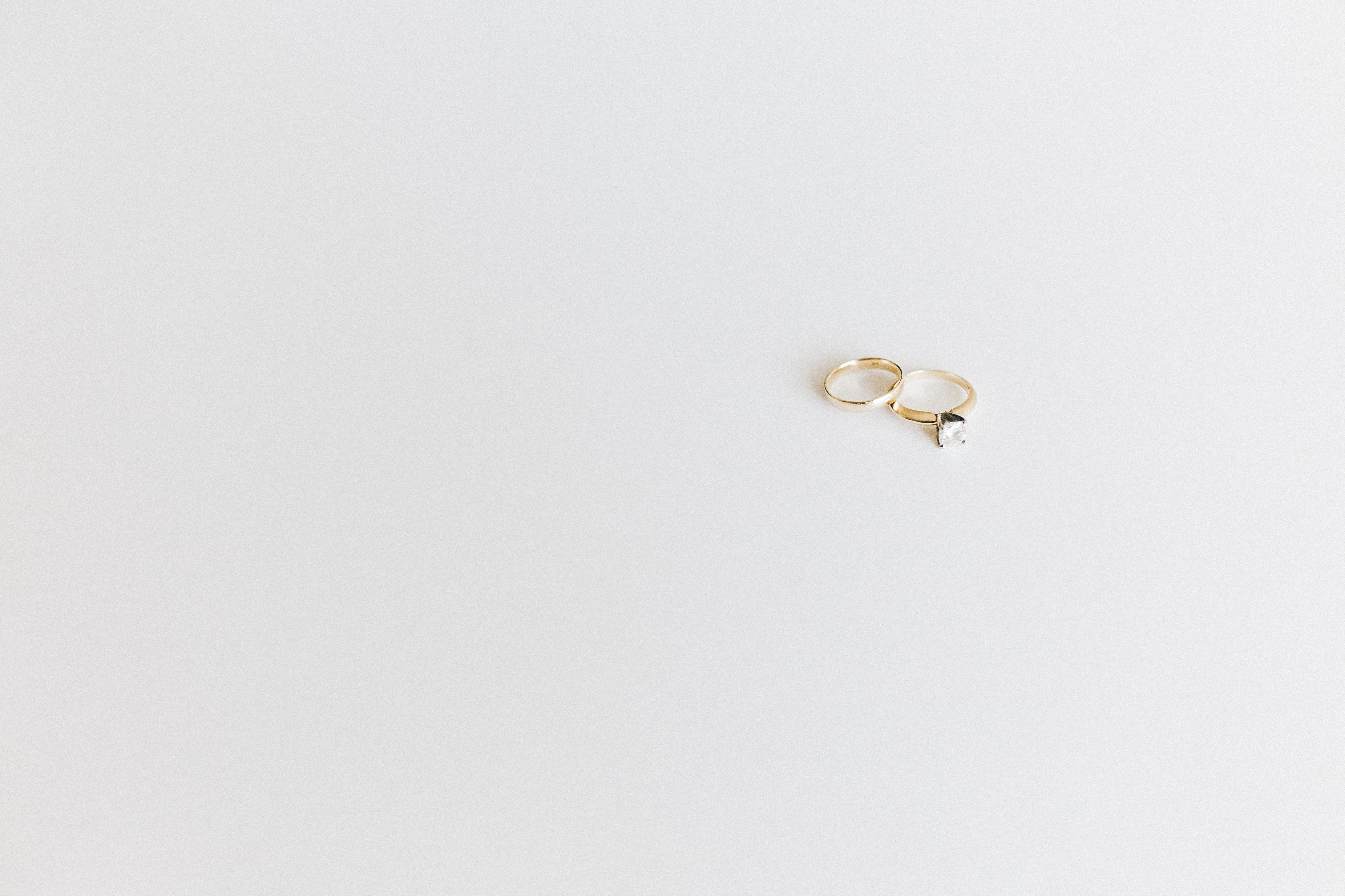 Free photo Two gold wedding rings on a light gray background