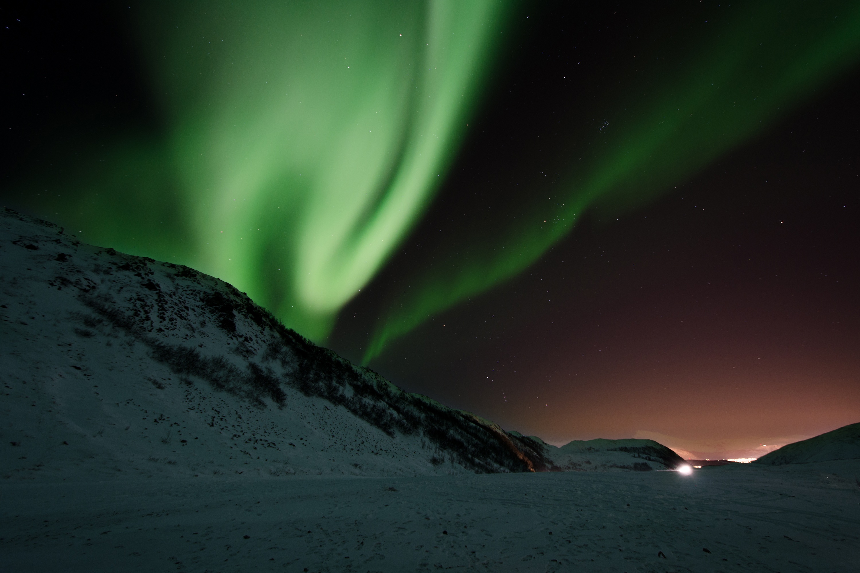 Northern Lights over snow-capped mountains