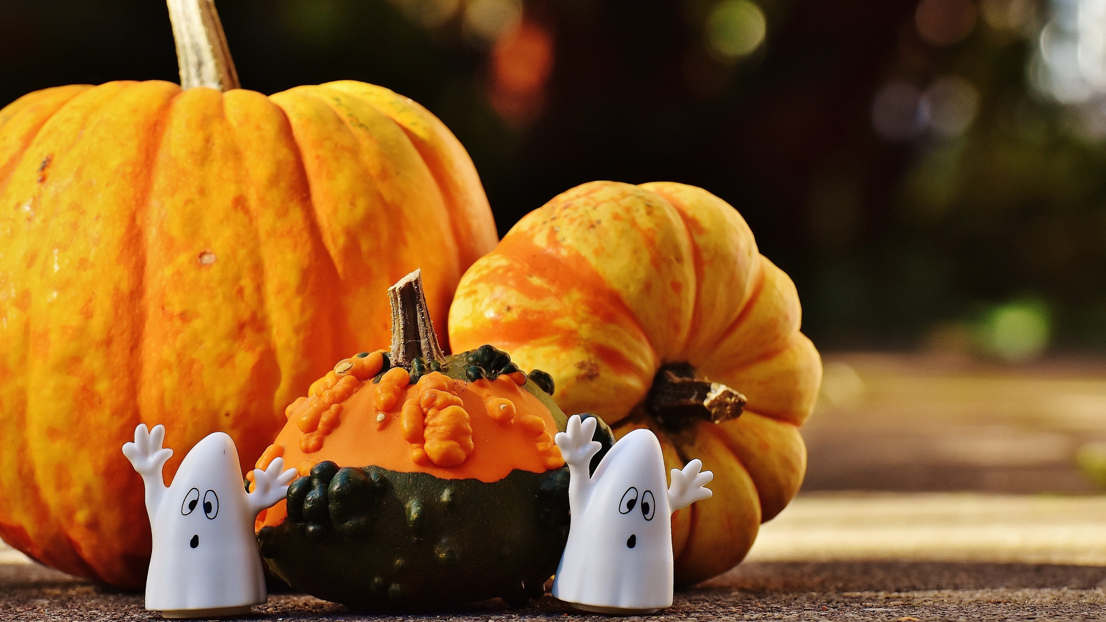 Free photo Toy ghosts next to the pumpkin