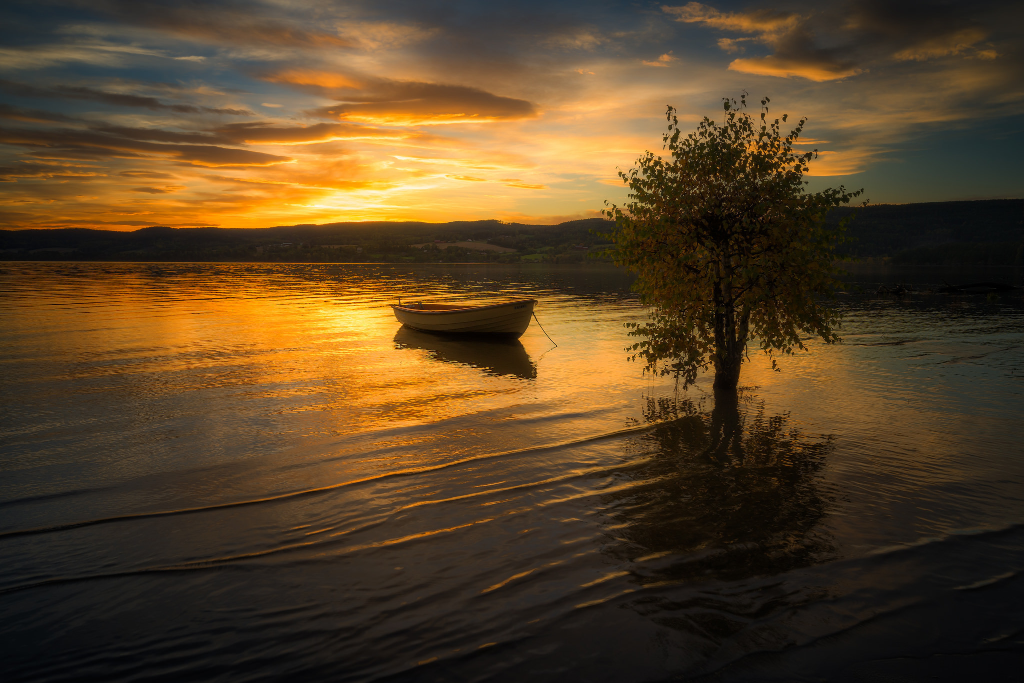 免费照片夕阳下的湖上木船