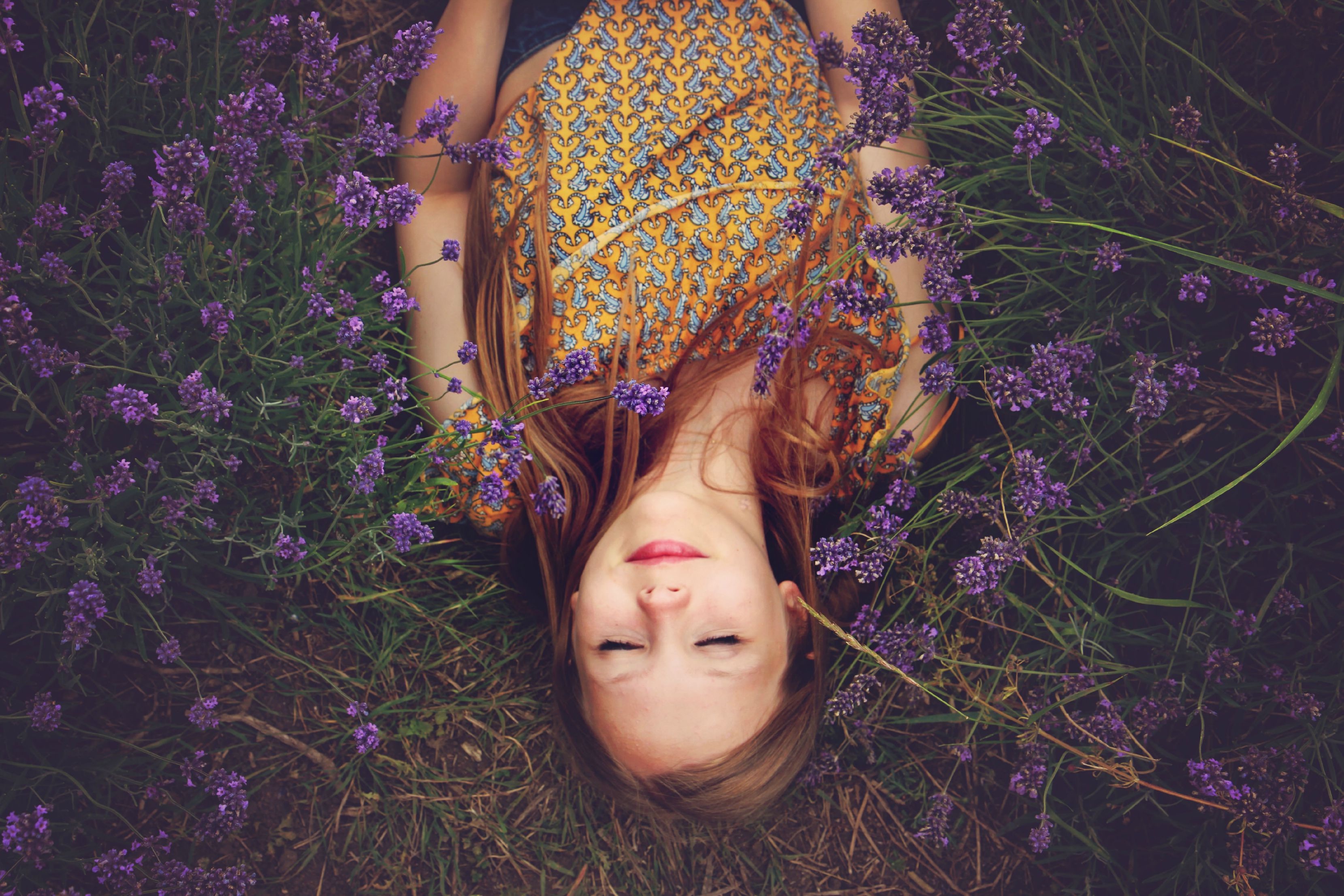 Free photo A girl lies in a field with purple flowers