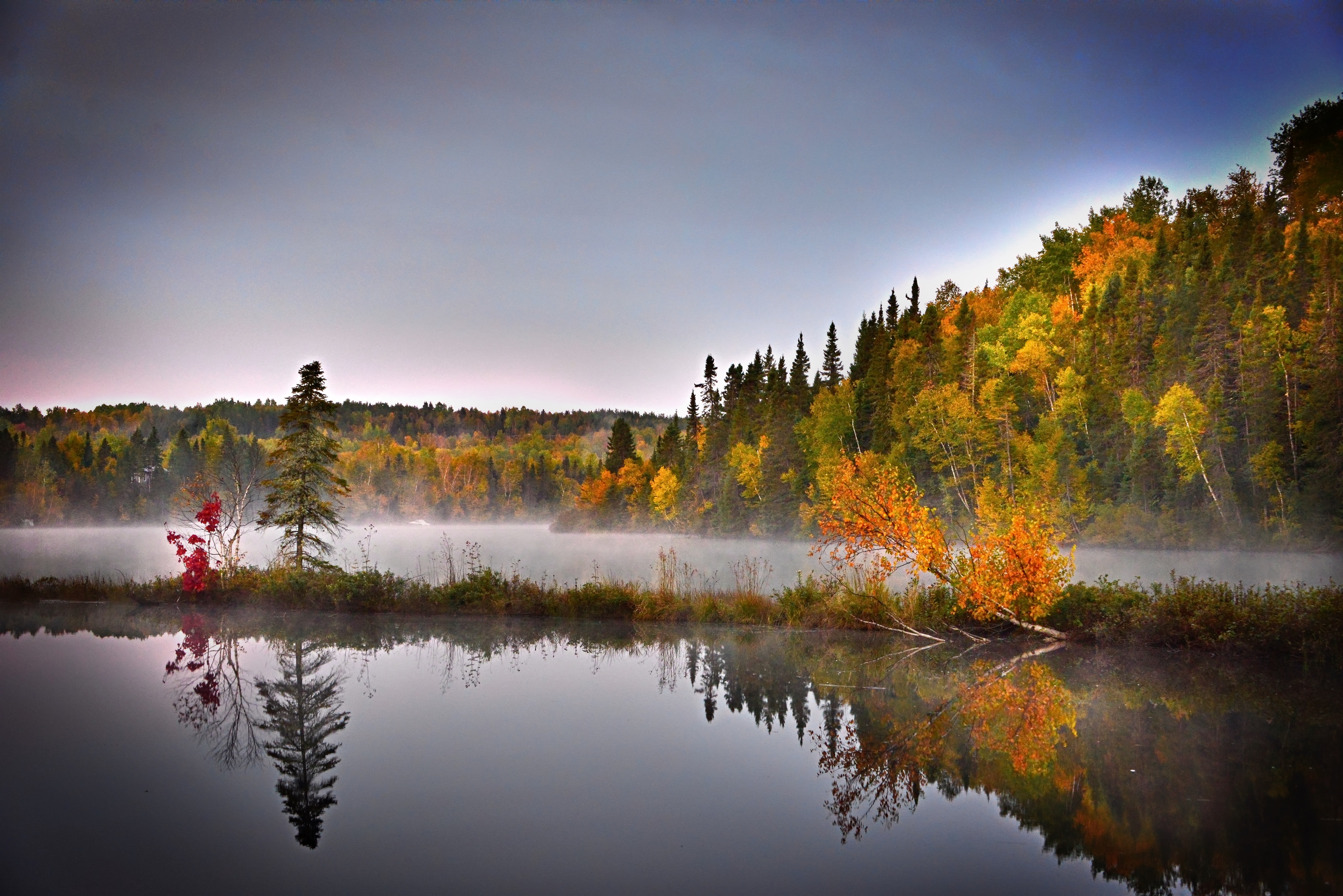 Free photo Smoke over the lake amidst the fall woods