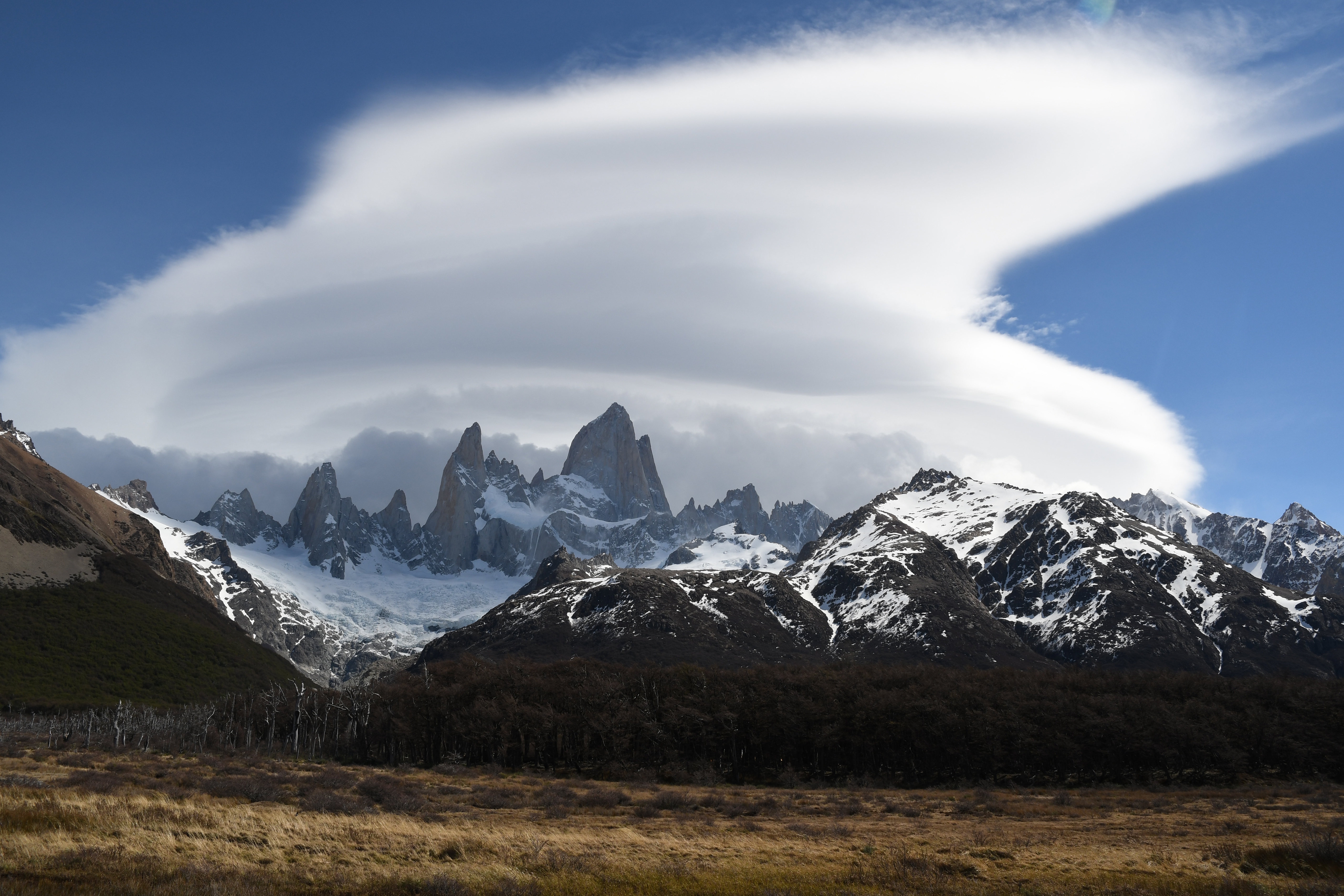 Free photo A big white cloud over a snowy mountain