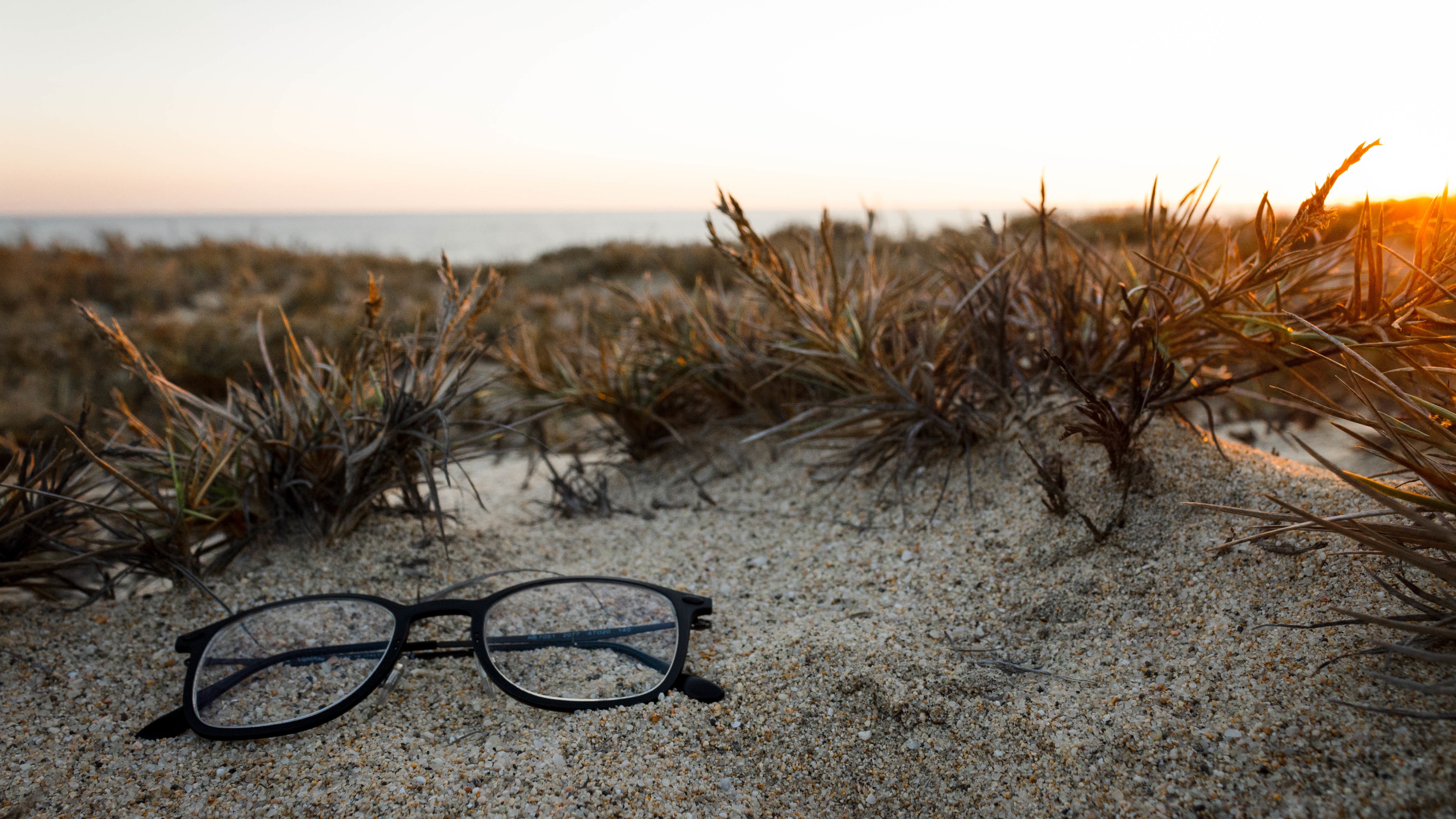 Free photo The glasses are lying on the sand