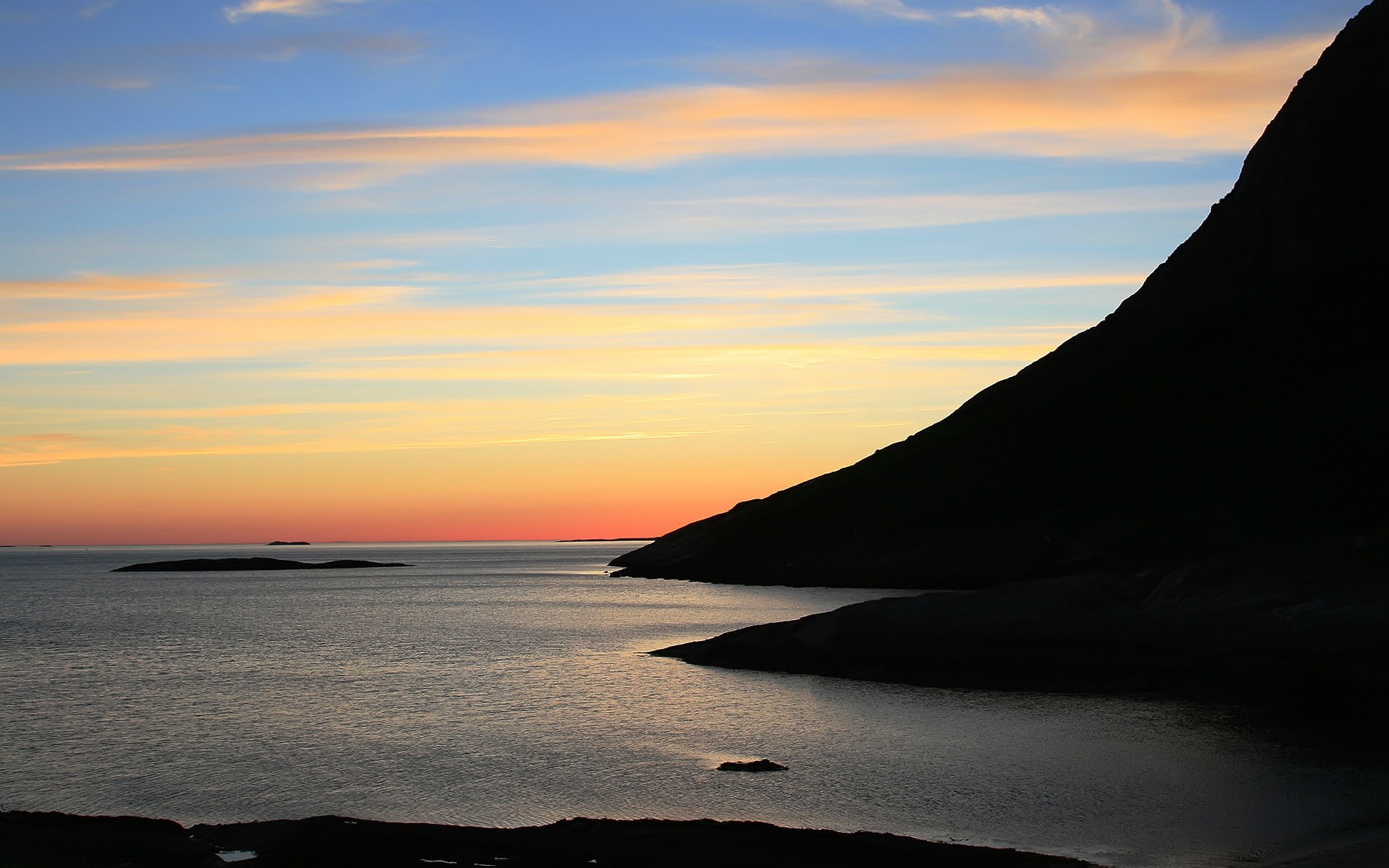 Free photo Silhouette of mountains in the evening by the sea