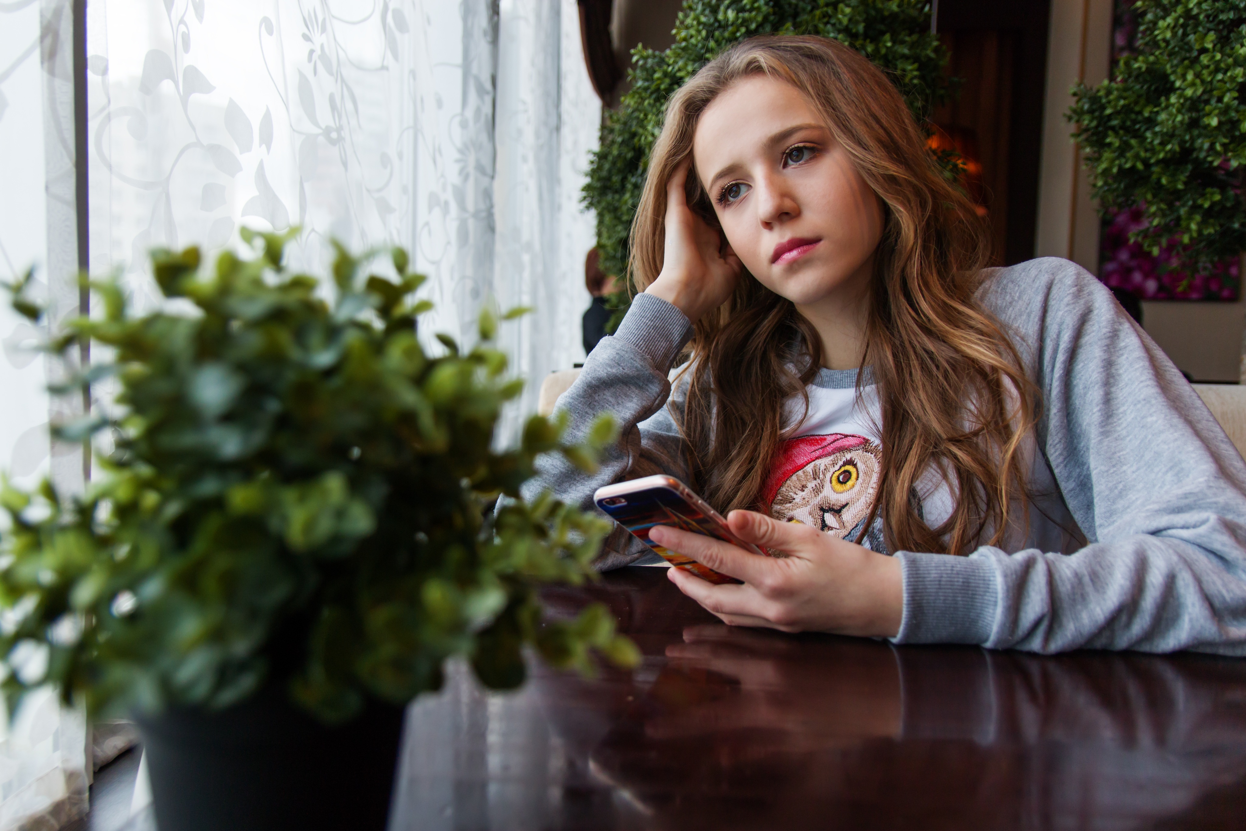 Free photo A pensive girl sitting in a cafe