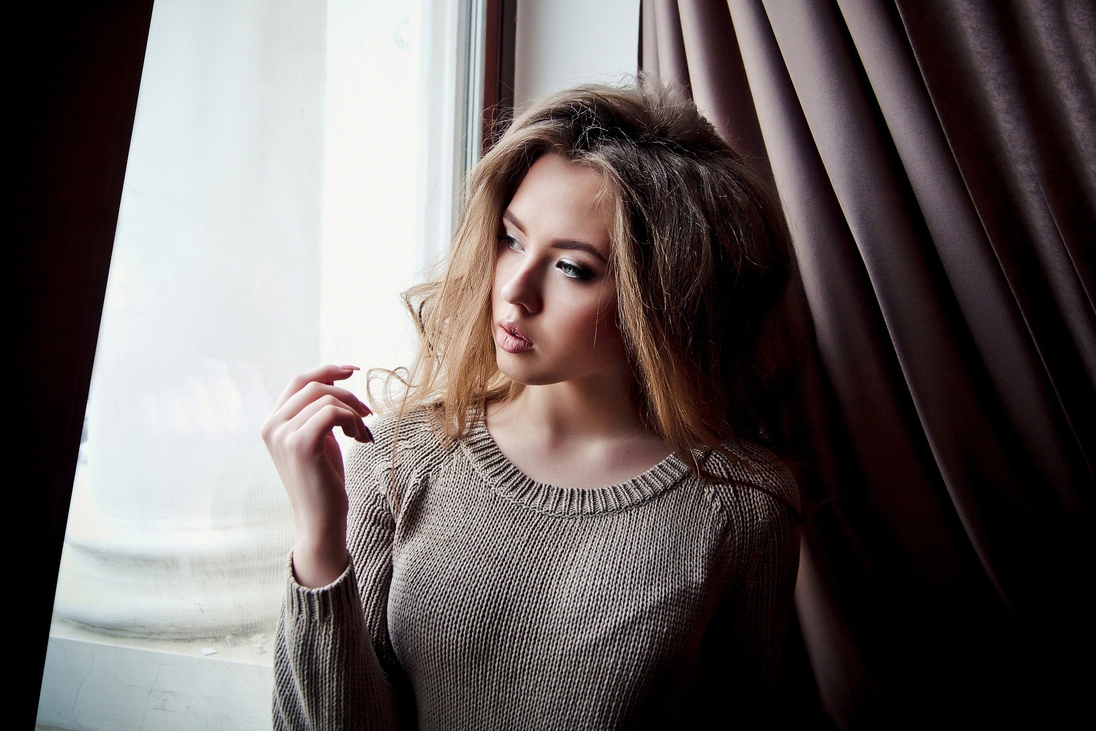 Free photo Beautiful dark-haired girl looking out the window