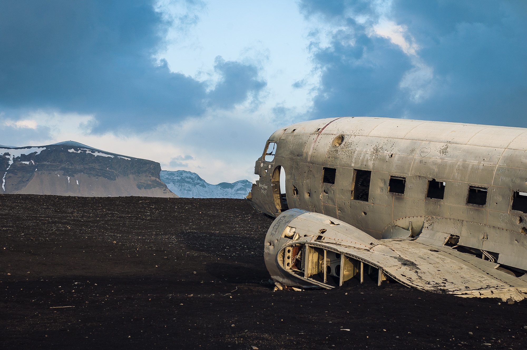 Free photo A downed airplane in a large field near the mountains