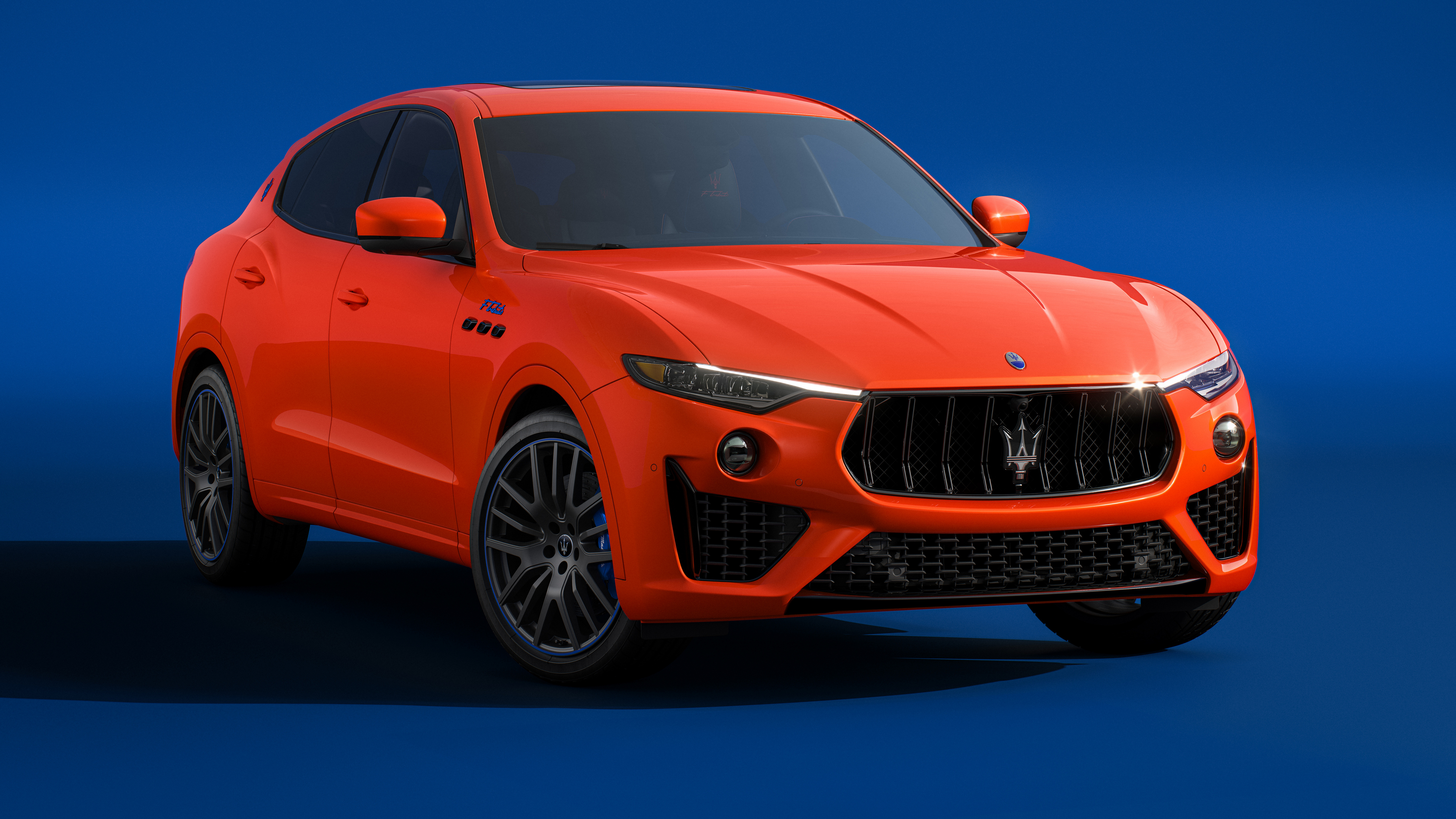 Free photo Orange 2022 Maserati Levante Ftributo on blue background