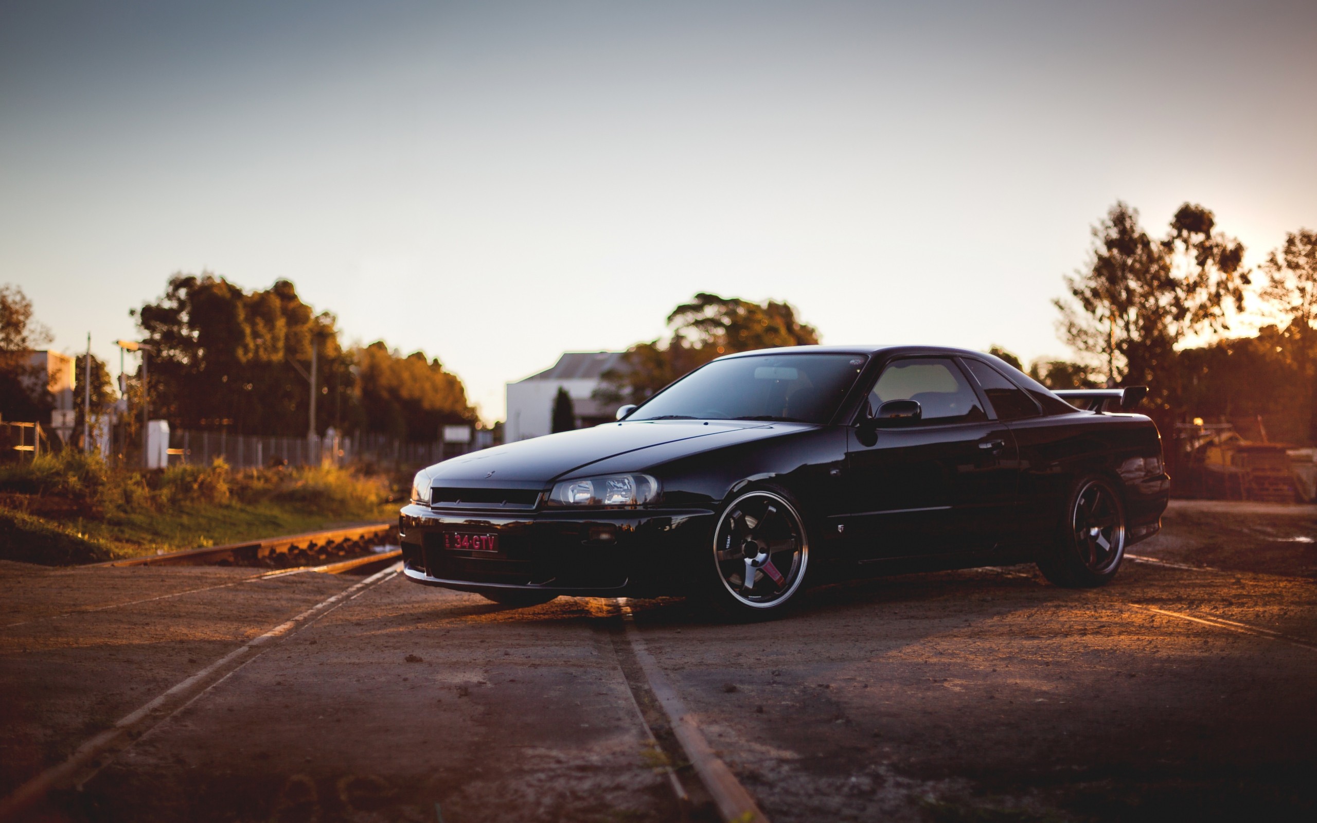 Free photo Black nissan skyline gt r with cool foxes at sunset