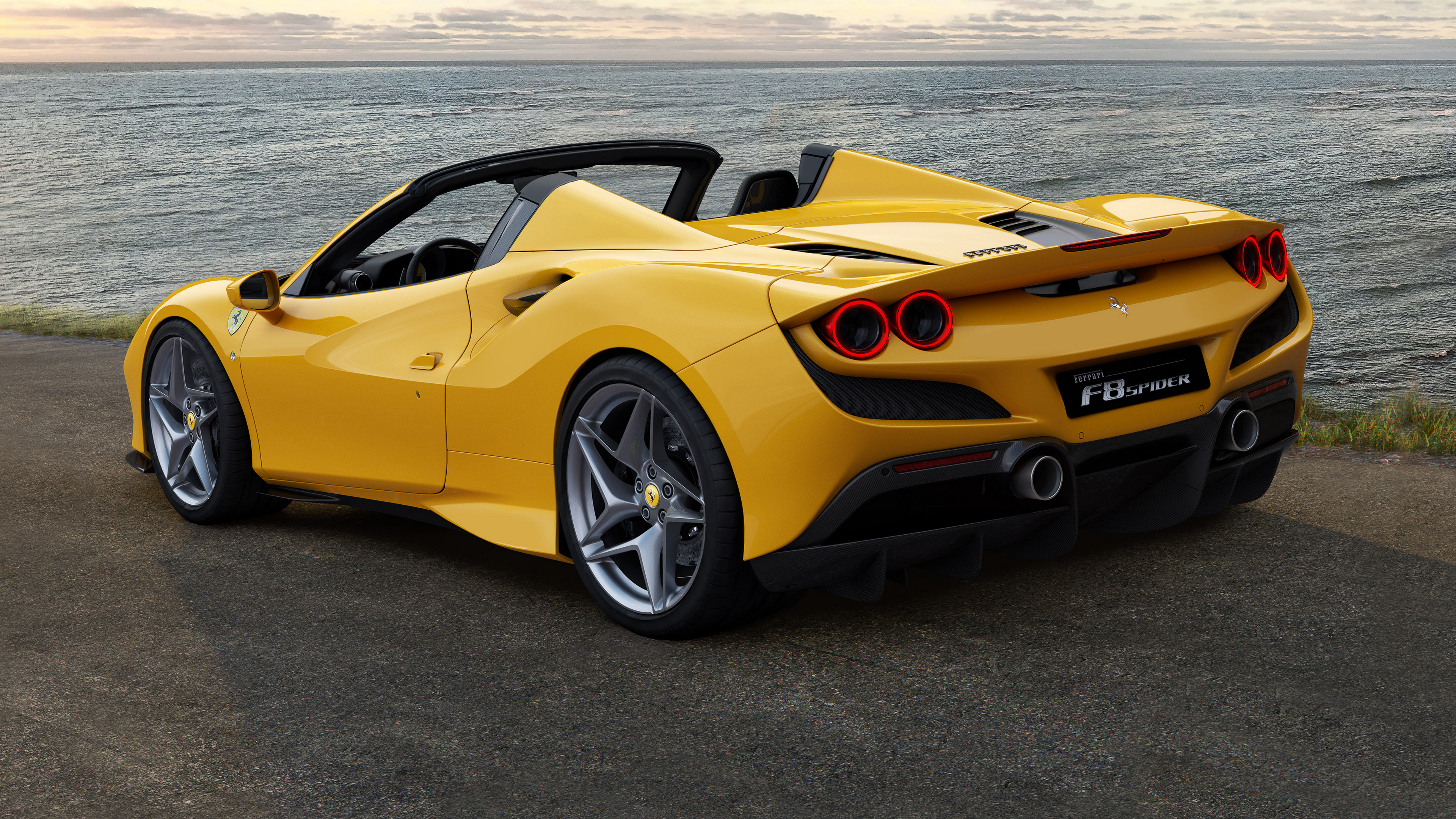 Бесплатное фото Желтая ferrari f8 spider 2019 года на берегу моря