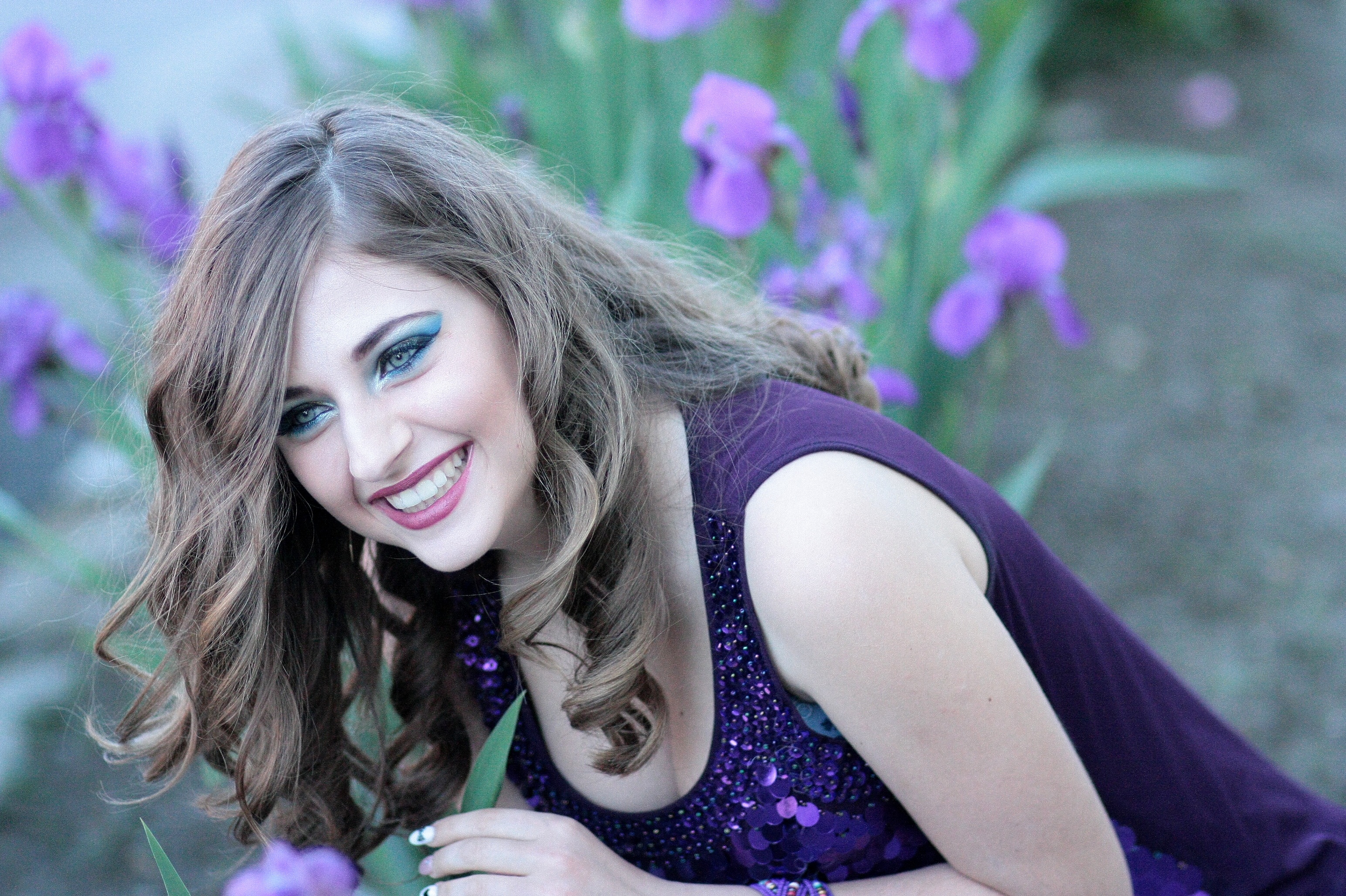 Free photo A happy brown-haired girl smiling in a garden with flowers