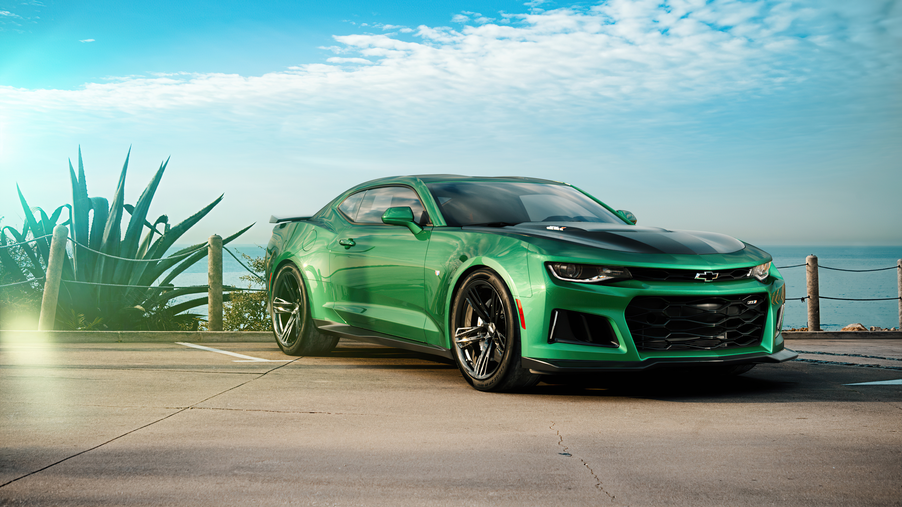 Бесплатное фото Зеленый Chevrolet Camaro стоит на фоне моря